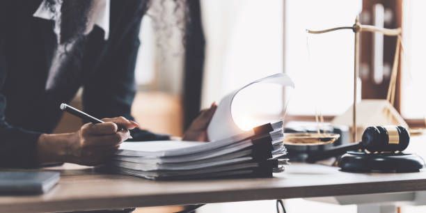 A lawyer is sitting at a desk writing on a piece of paper.