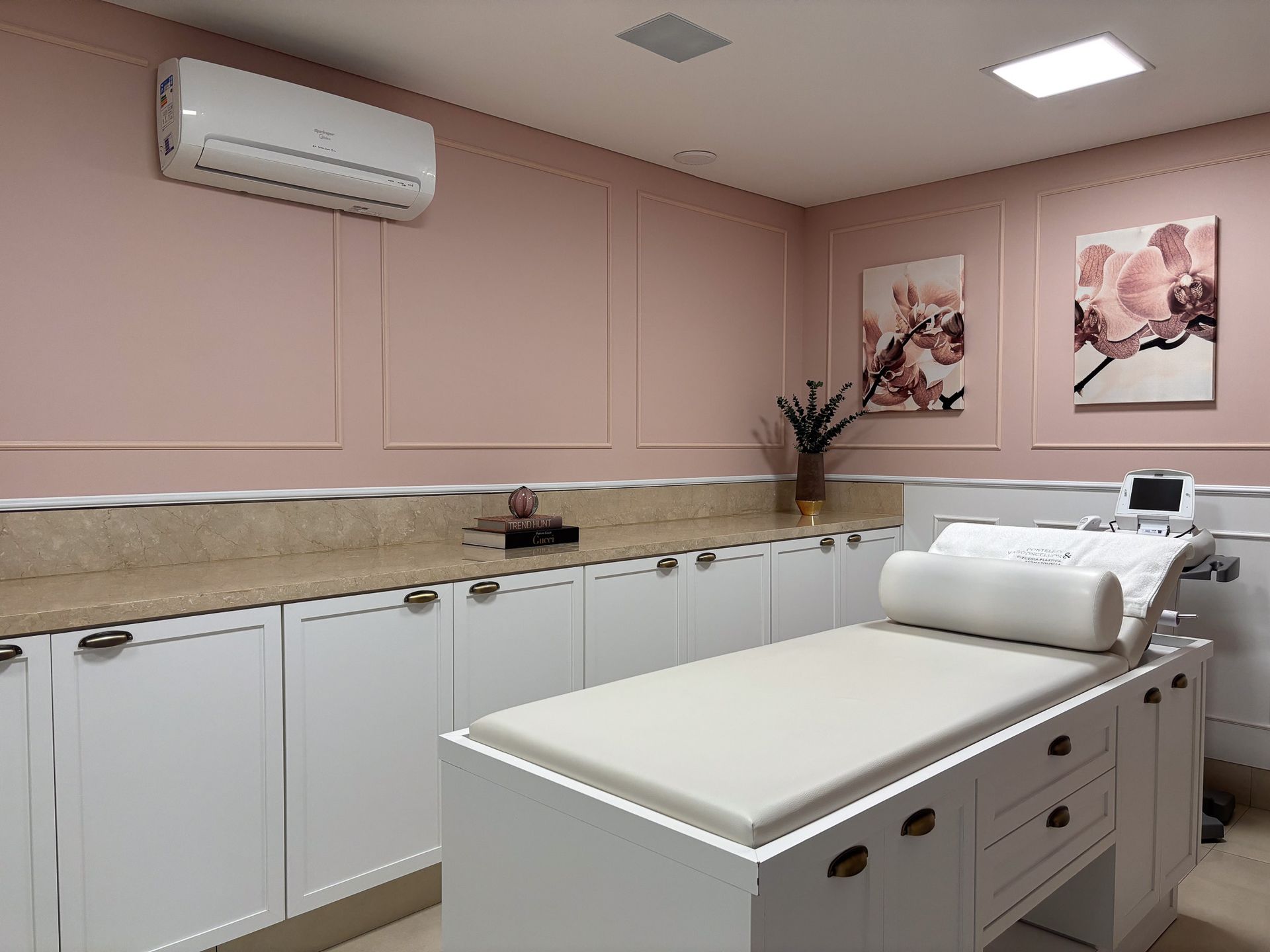 Há uma cama no meio de um quarto com paredes rosa.