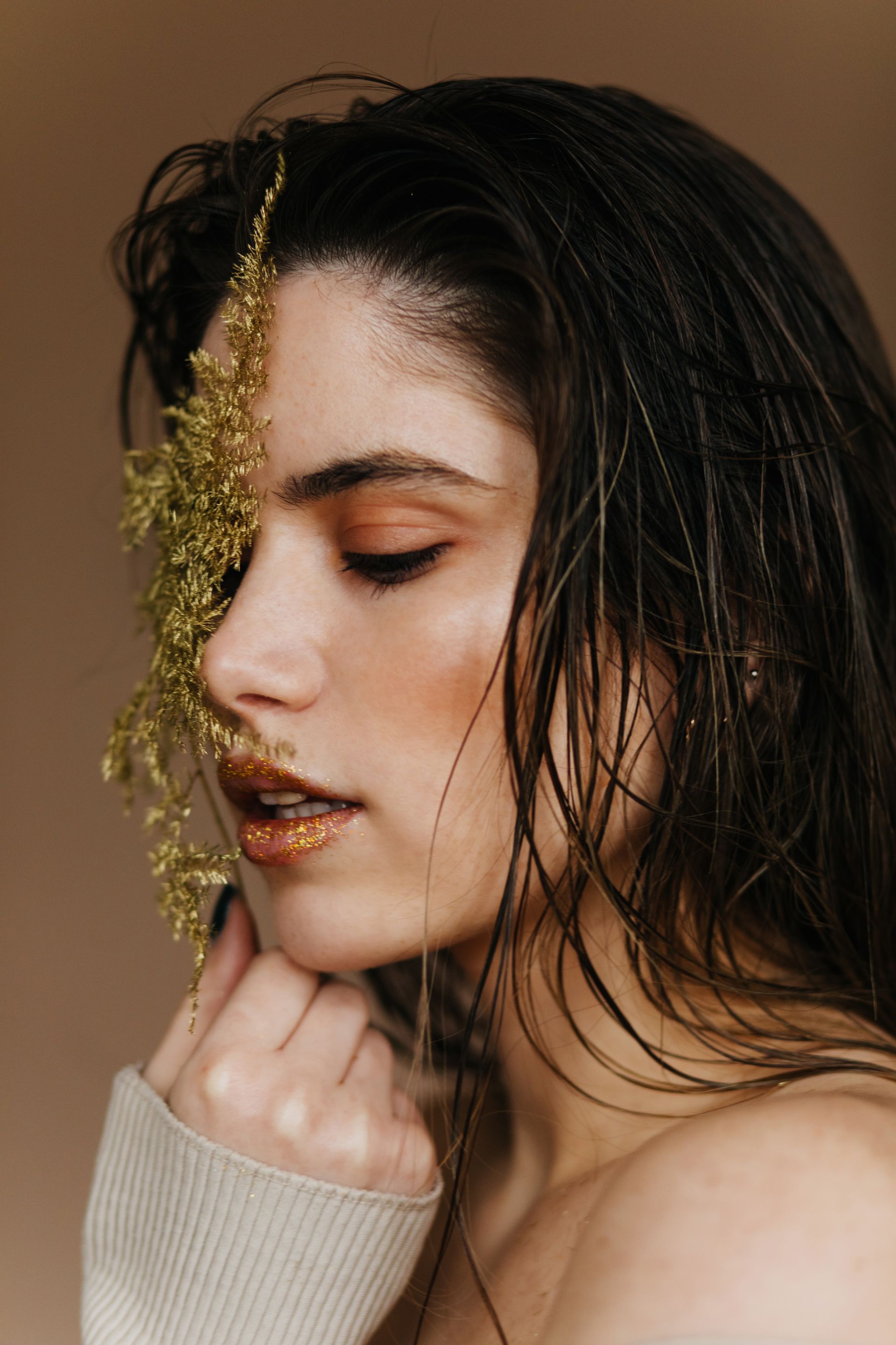 Um close do rosto de uma mulher com uma flor no cabelo.