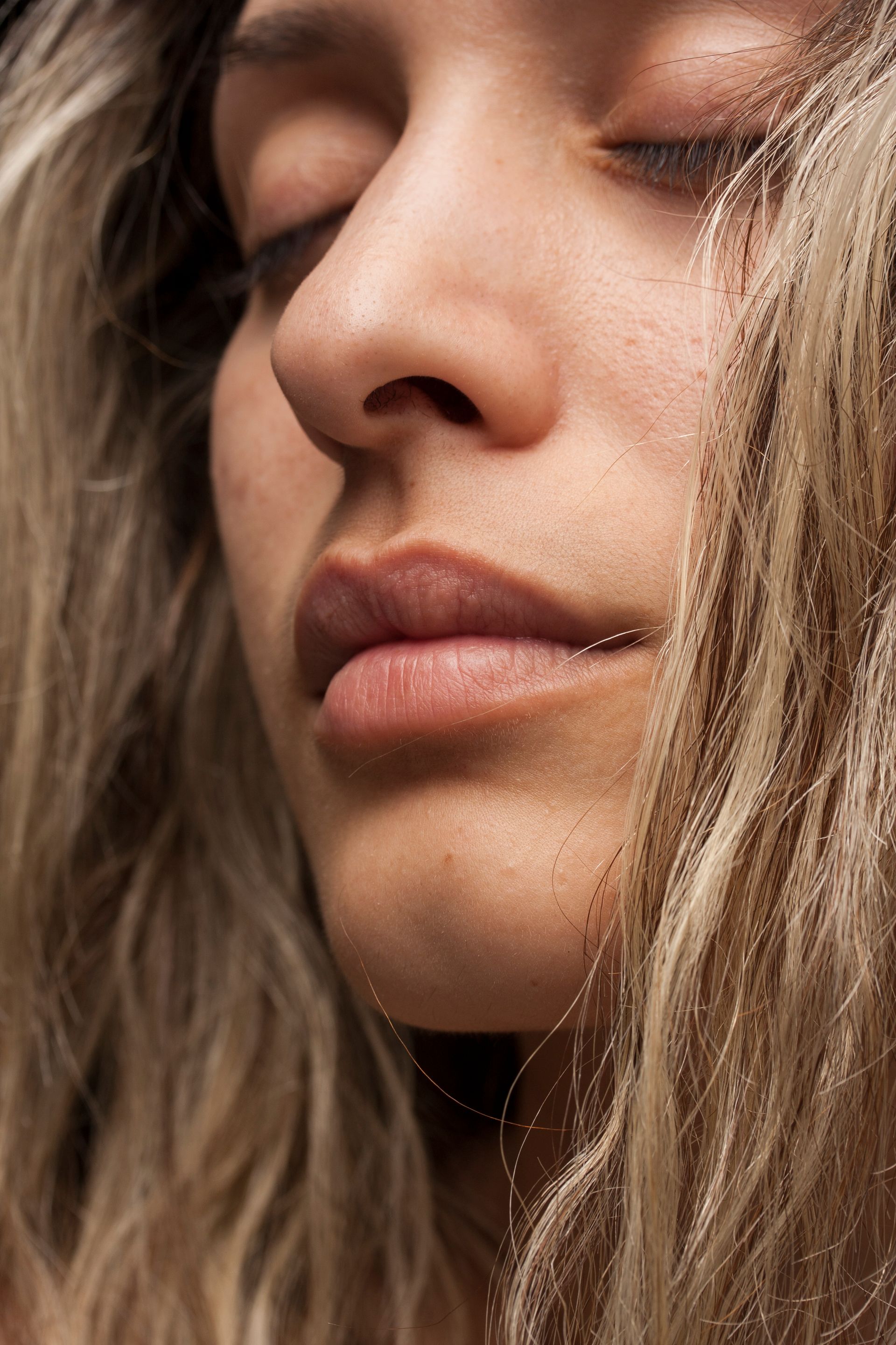 Um close do rosto de uma mulher com os olhos fechados.