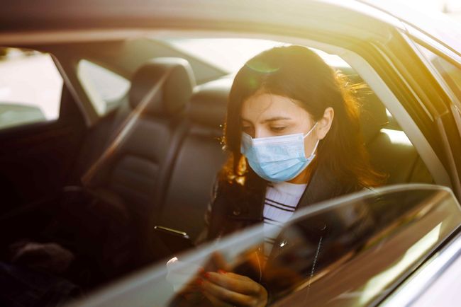 Texas Senior Care Transsport_Passenger sitting in car, looking at cell phone