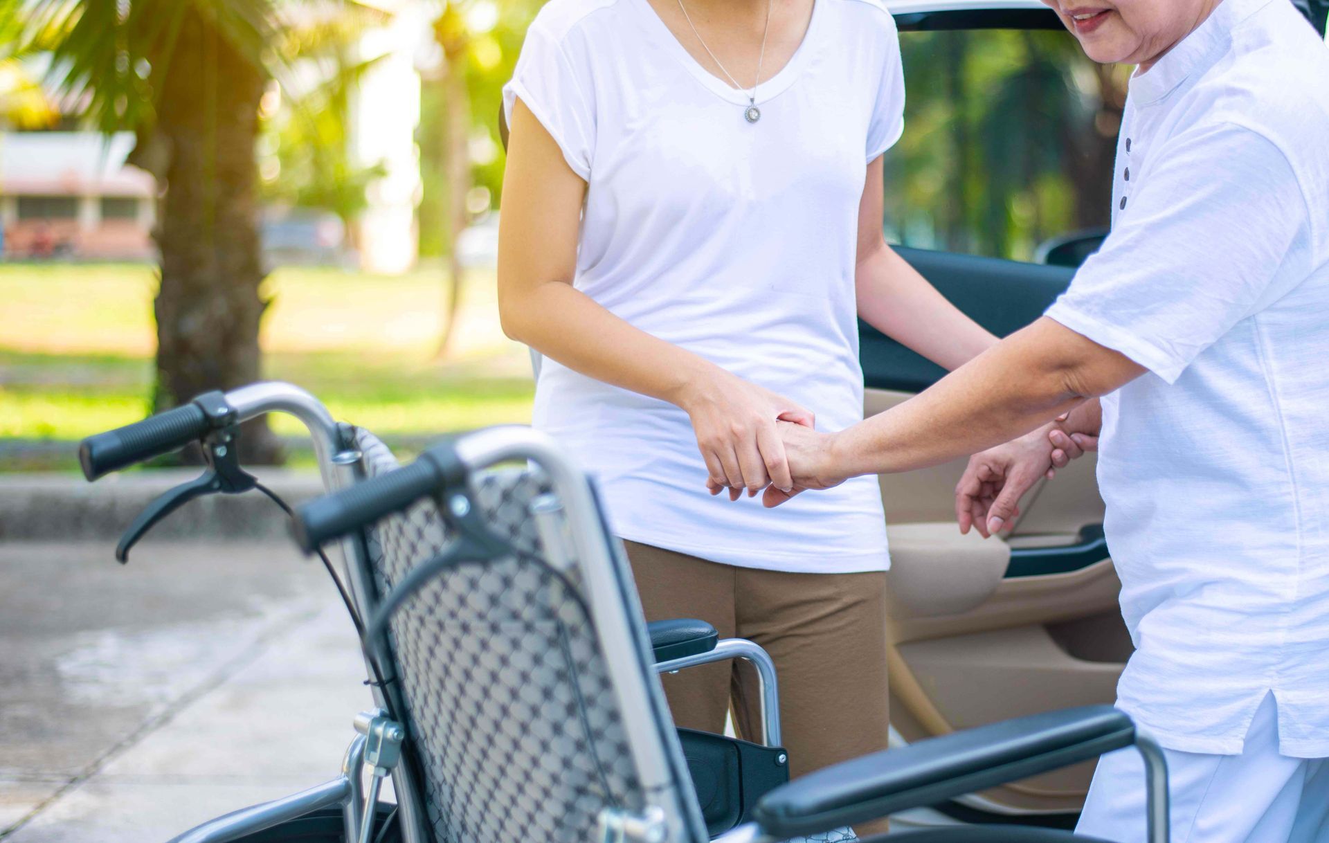 Texas Senior Care Transpor_Caregiver helping a patient to stand up from the wheelchair