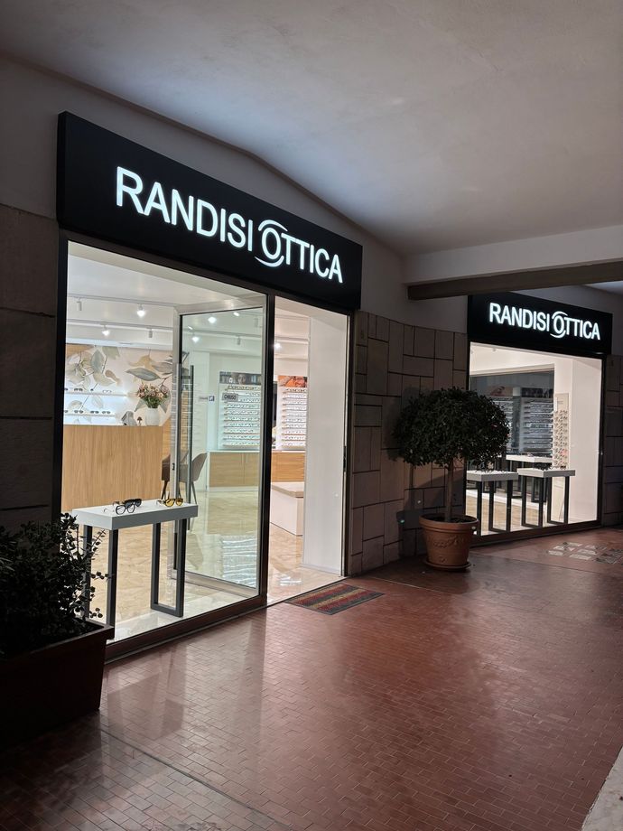 Un uomo e una donna in piedi davanti a un negozio di ottica randisi