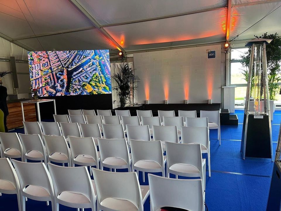 Frametent ingericht voor een presentatie met stoelenrijen en scherm