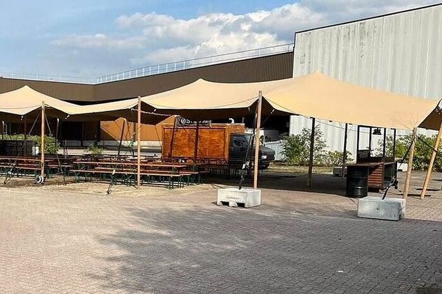 Ballastblokken bij de palen van een stretchtent