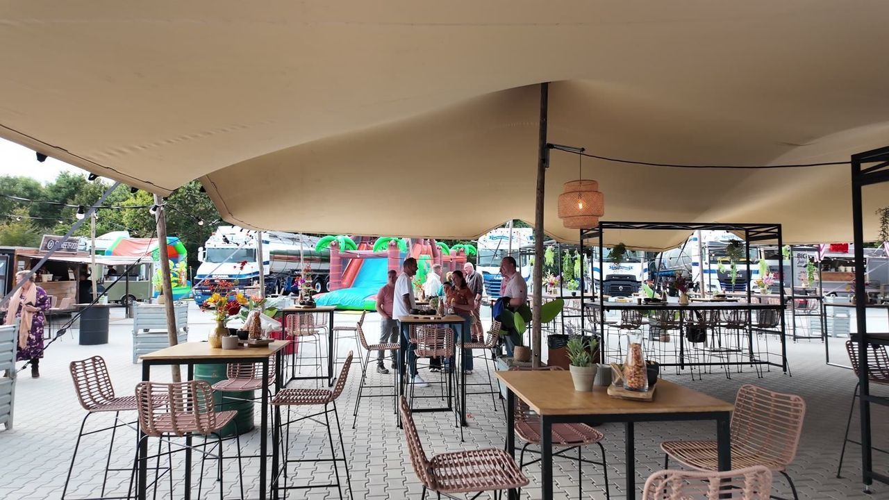 Stretchtent met statafels en rieten stoelen