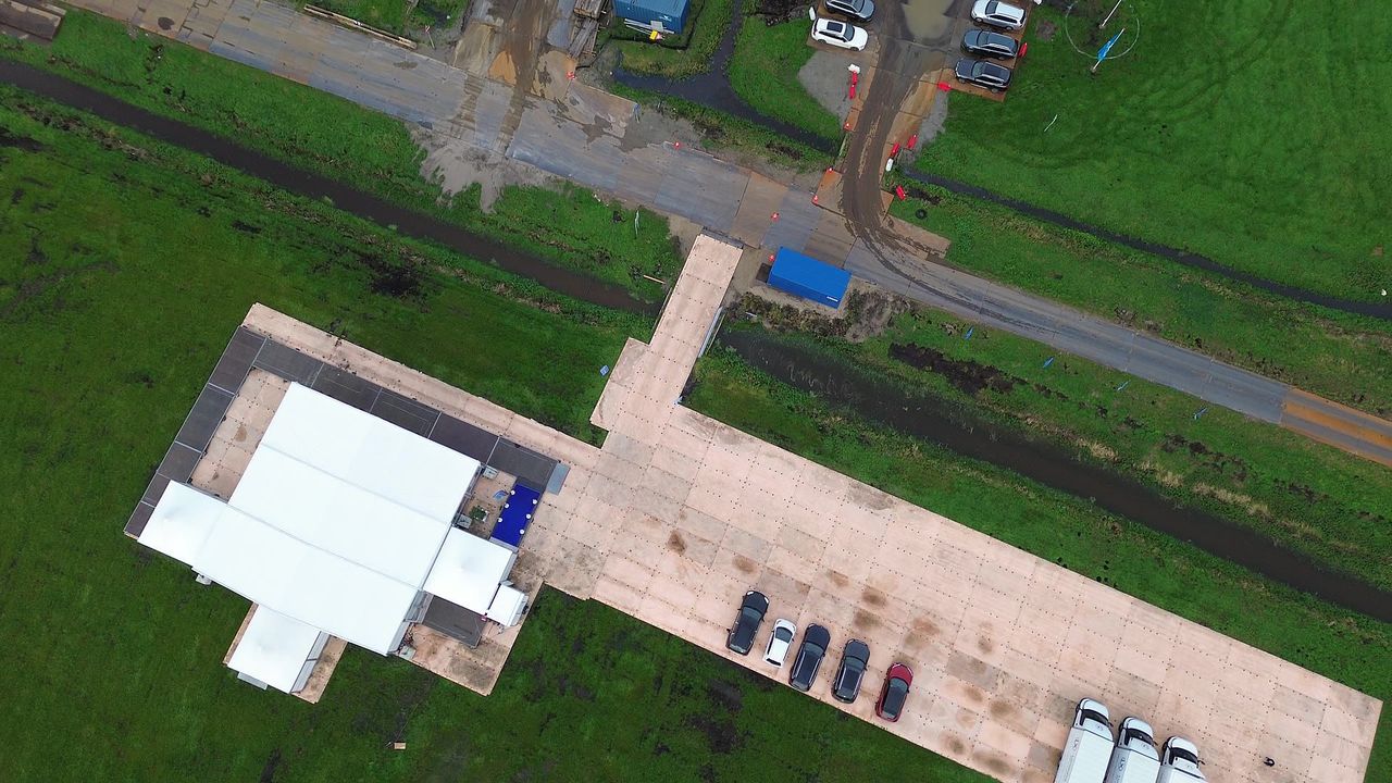 De frametent en de parkeerplaats op het weiland, van boven