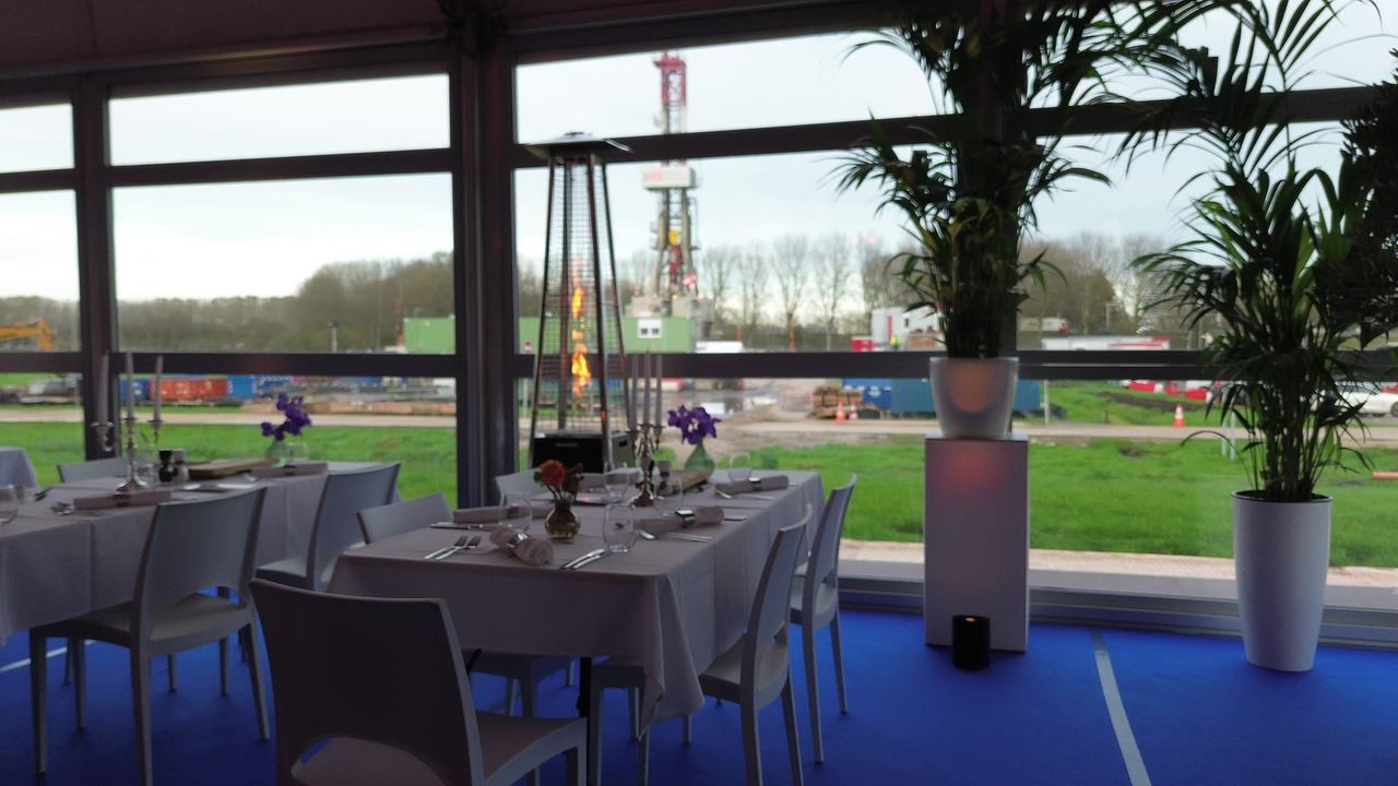Gedekte tafels bij de glazen wand
