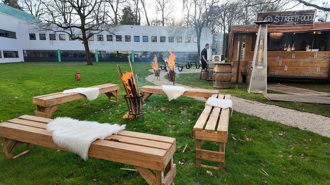 Vuurkorf met houten banken en schapenvachten