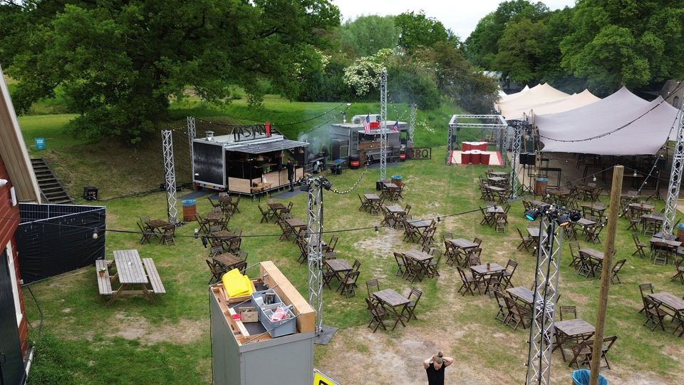 Foodtrucks en tafels naast de stretchtent