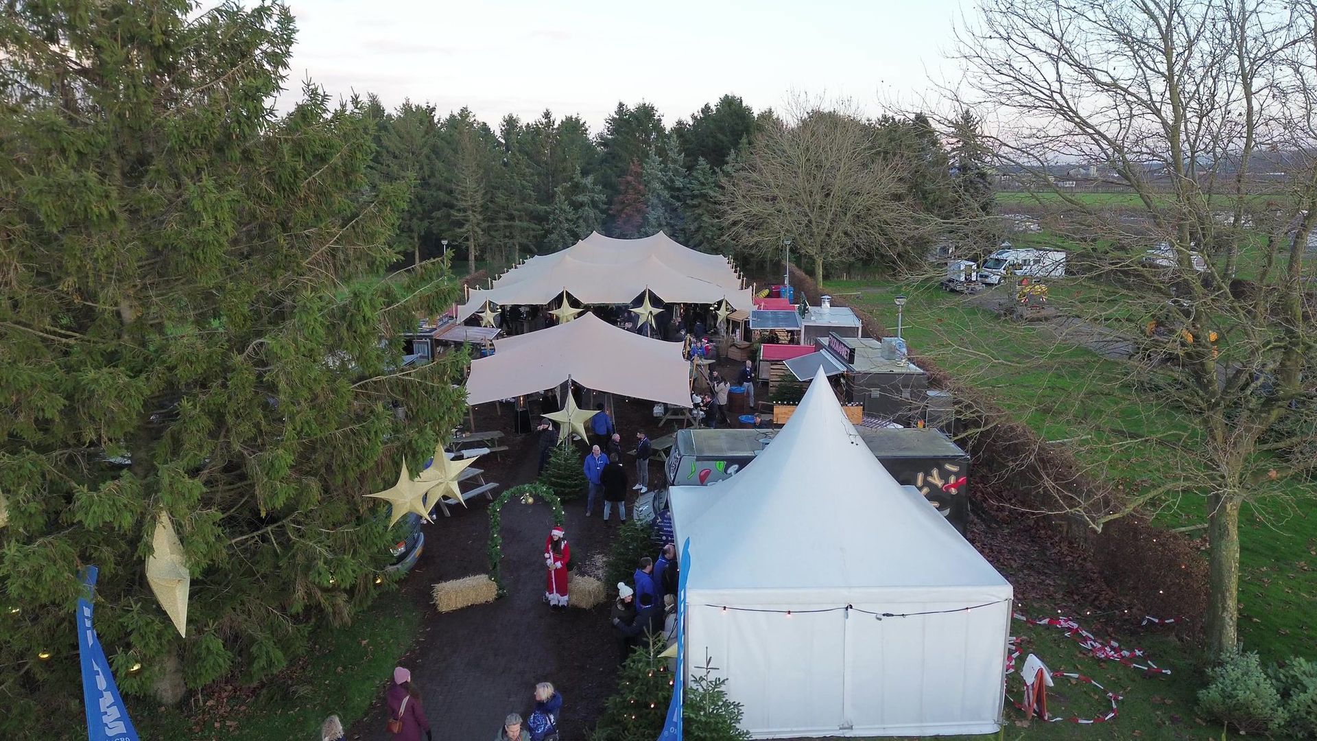 Stretchtenten en een pagodetent met sterren op de kerstmarkt, van boven
