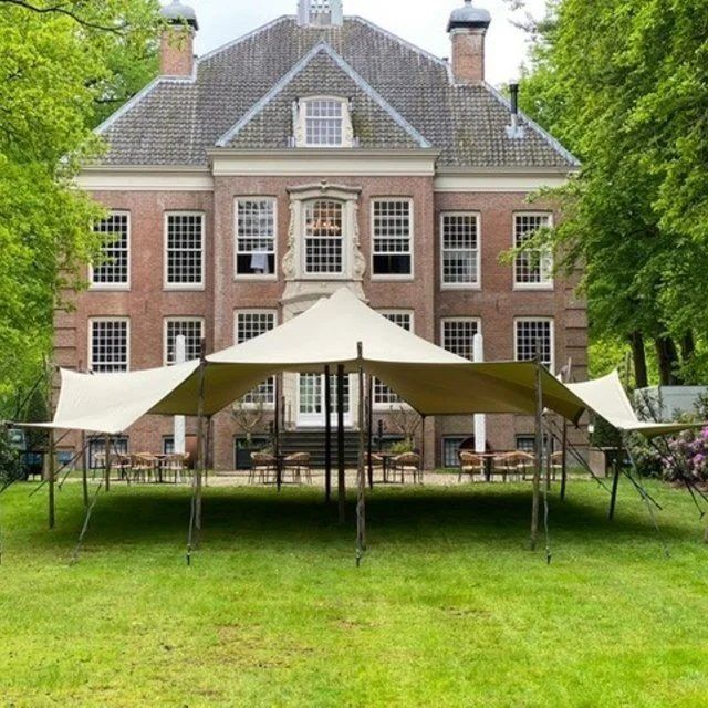 Stretchtent van 10 × 12 meter in zandkleur voor een landhuis