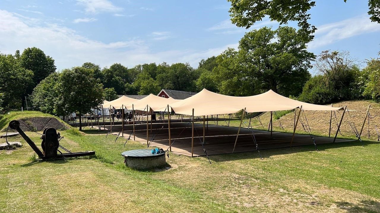 Stretchtent van 12 × 30 meter op een grasveld
