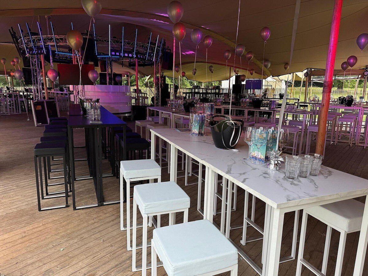 Bar met witte krukken onder een stretchtent