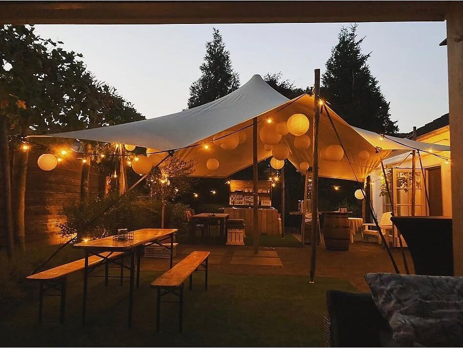 Stretchtent met lampionnen bij zonsondergang
