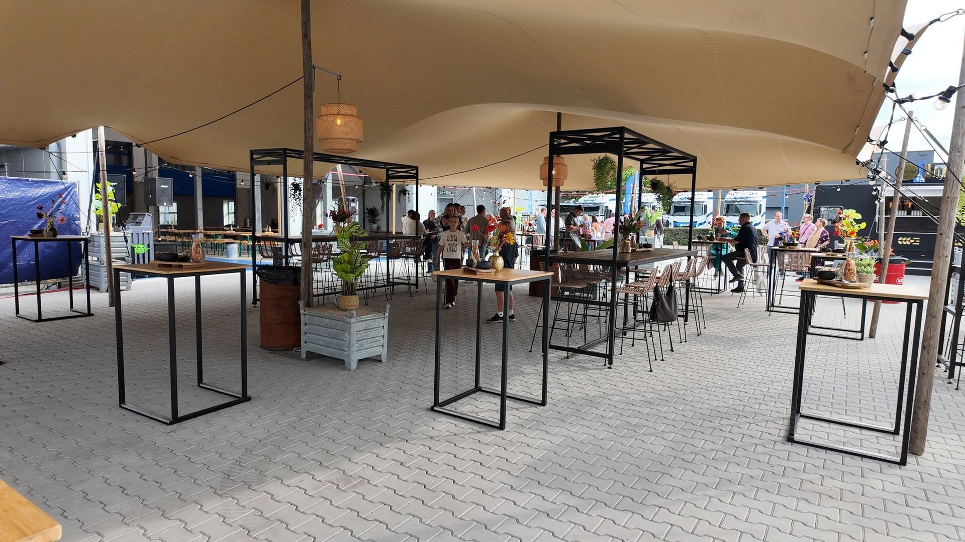 Stretchtent ingericht met statafels en bloemen