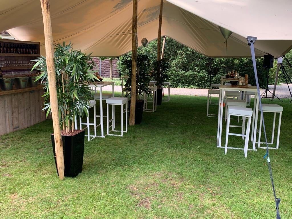 Statafels en planten onder een stretchtent