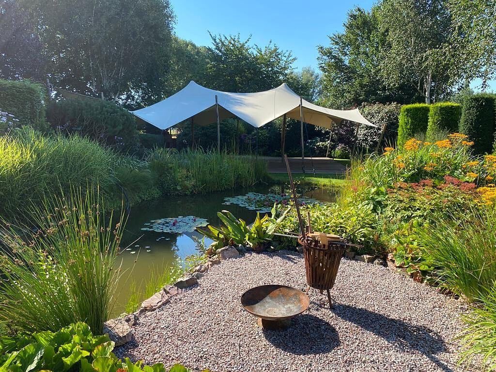 Stretchtent bij een vijver in een tuin