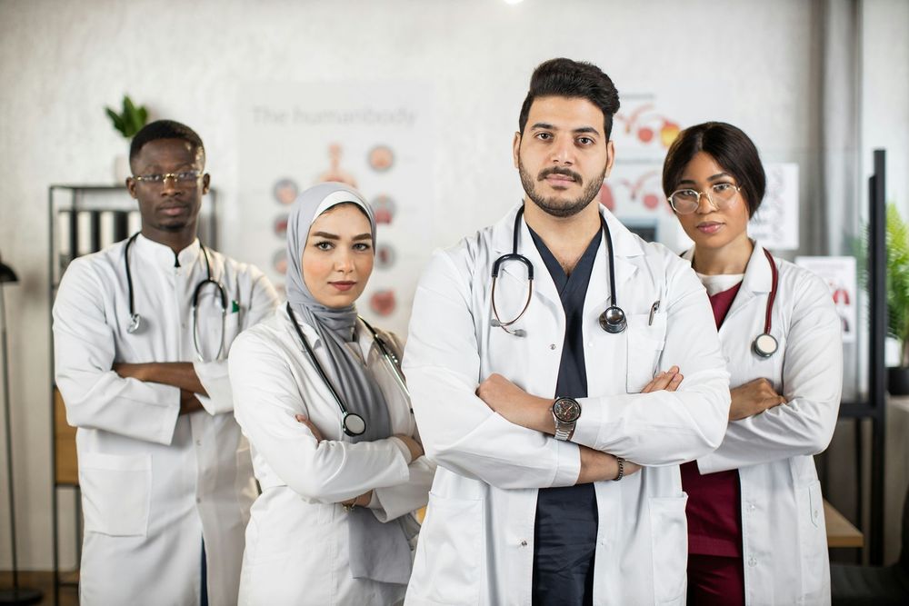 A group of doctors standing next to each other with their arms crossed.