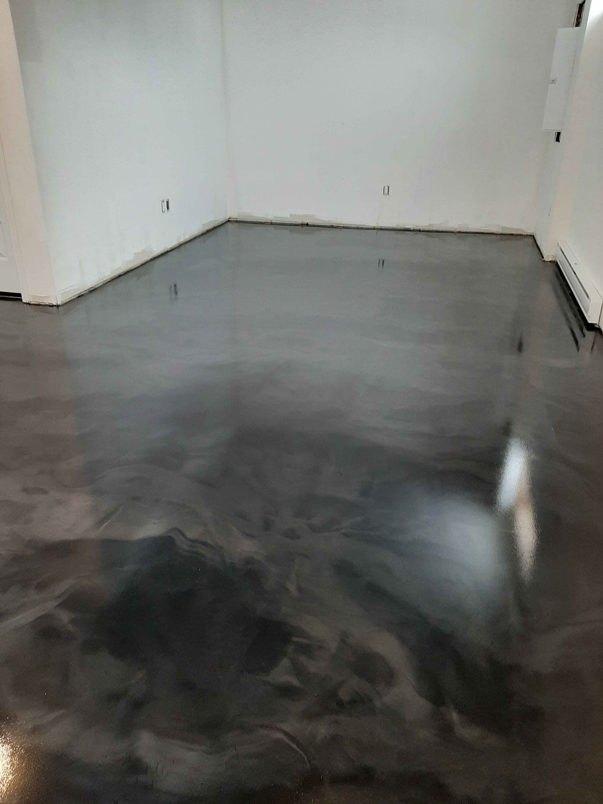 A room with a black metallic floor and white walls.