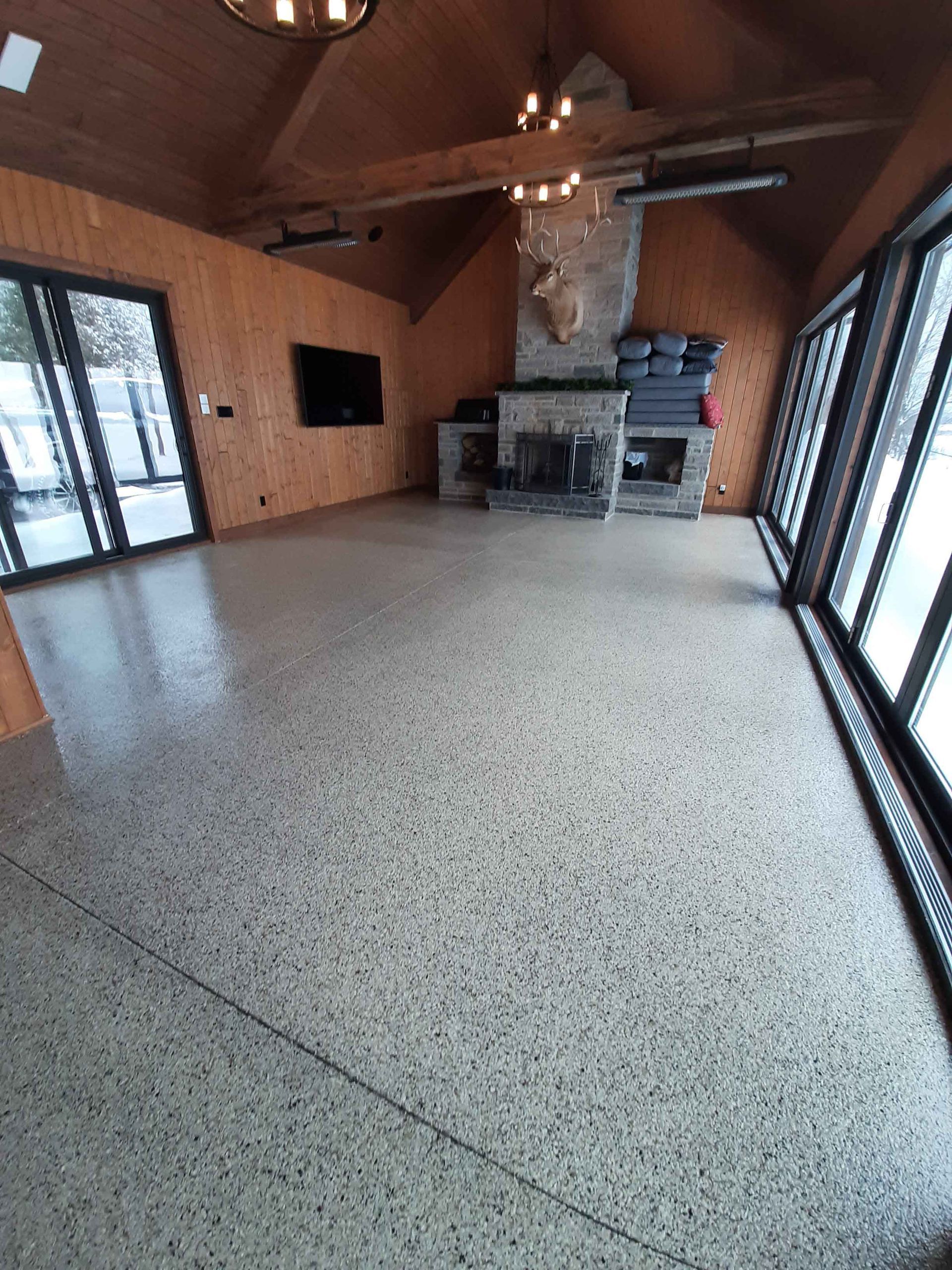 A large room with a fireplace and lots of windows.
