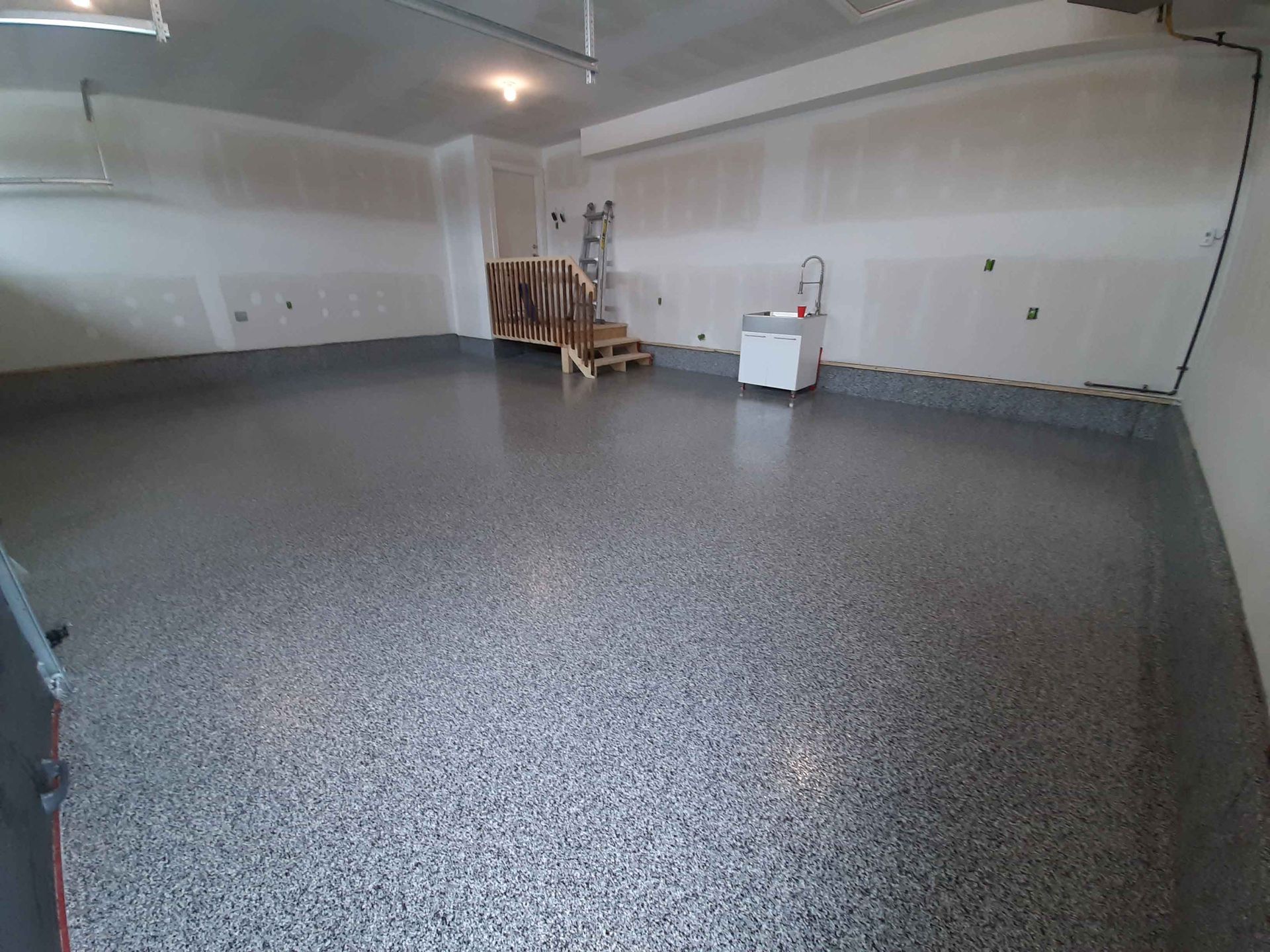 A garage with a gray floor and white walls.