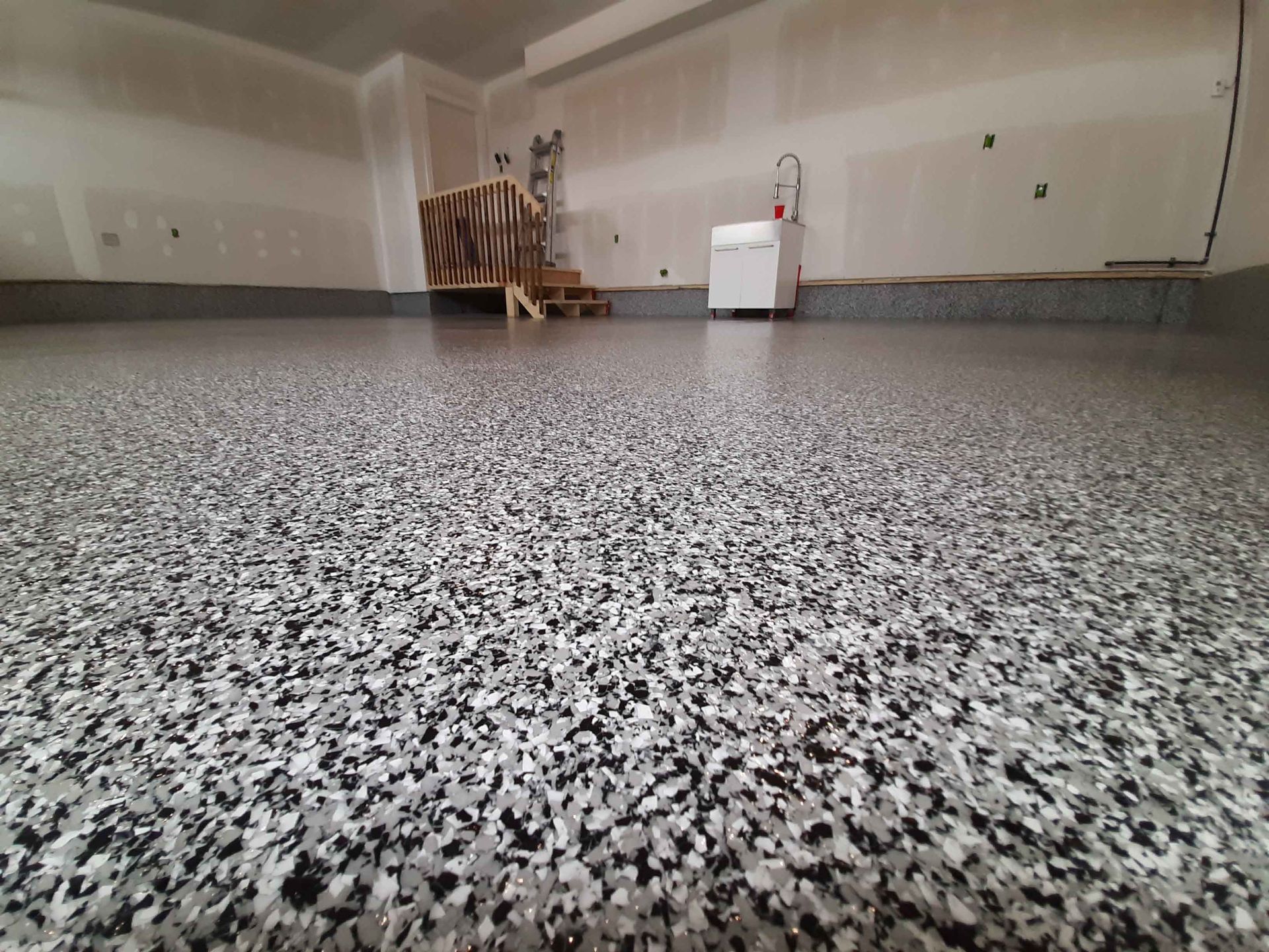 A garage with a black and white floor and white walls.