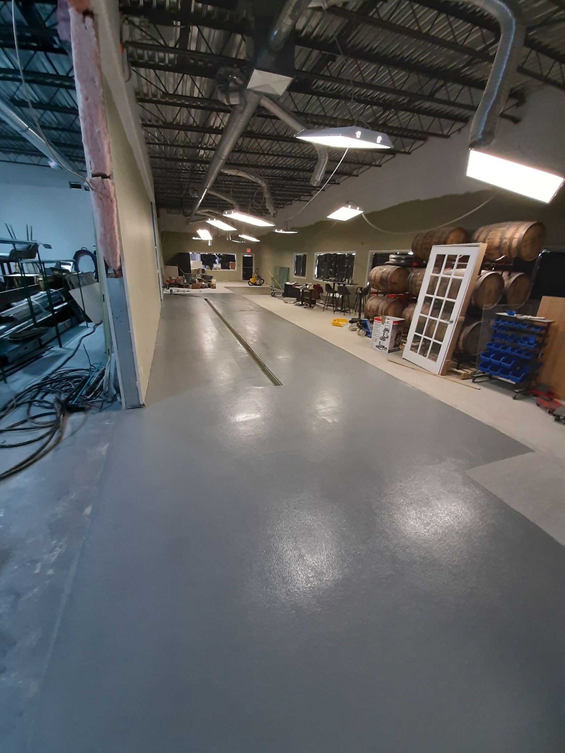 A large room with a gray floor and a lot of furniture in it.