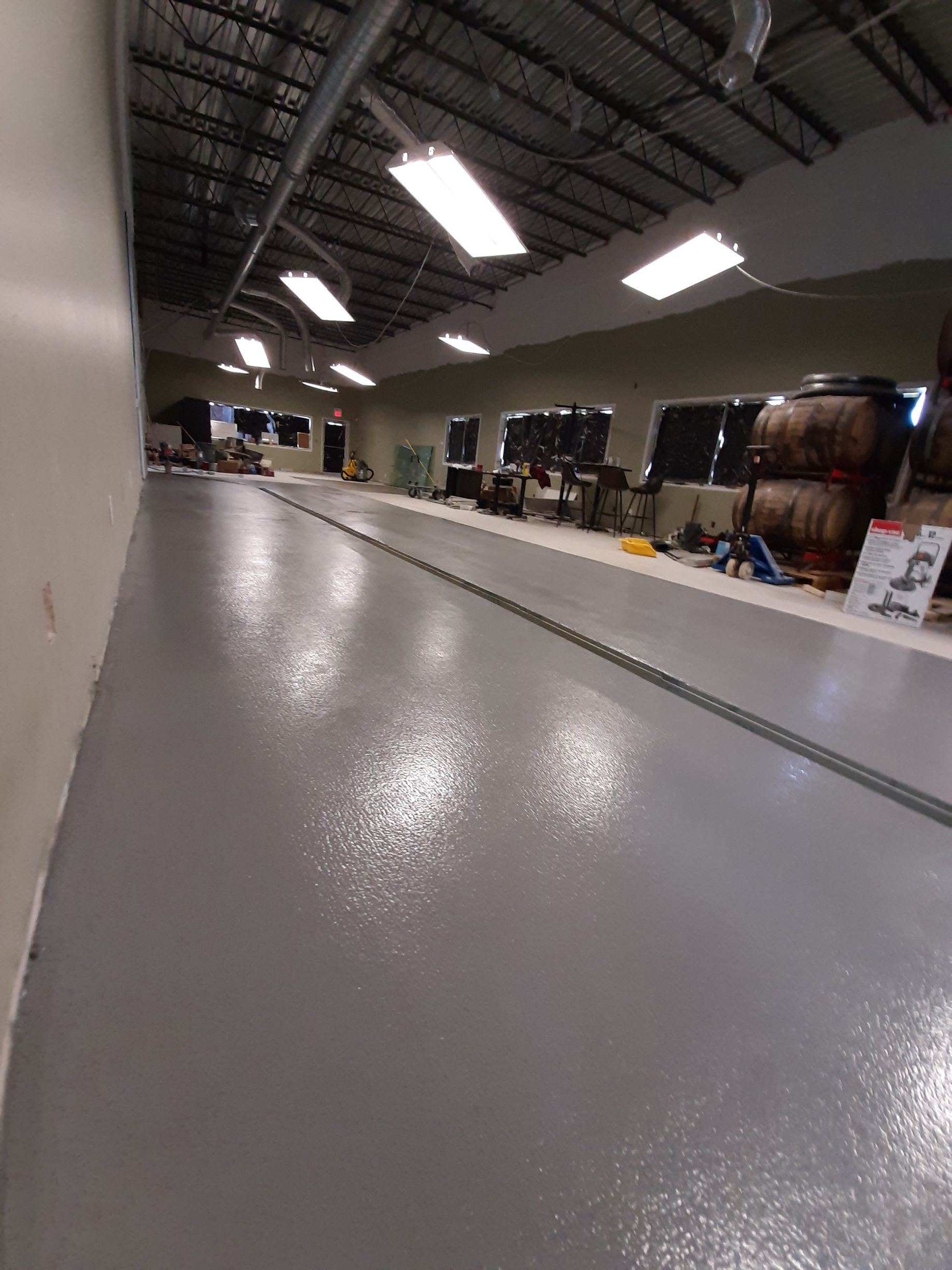 A long hallway in a building with a gray floor.