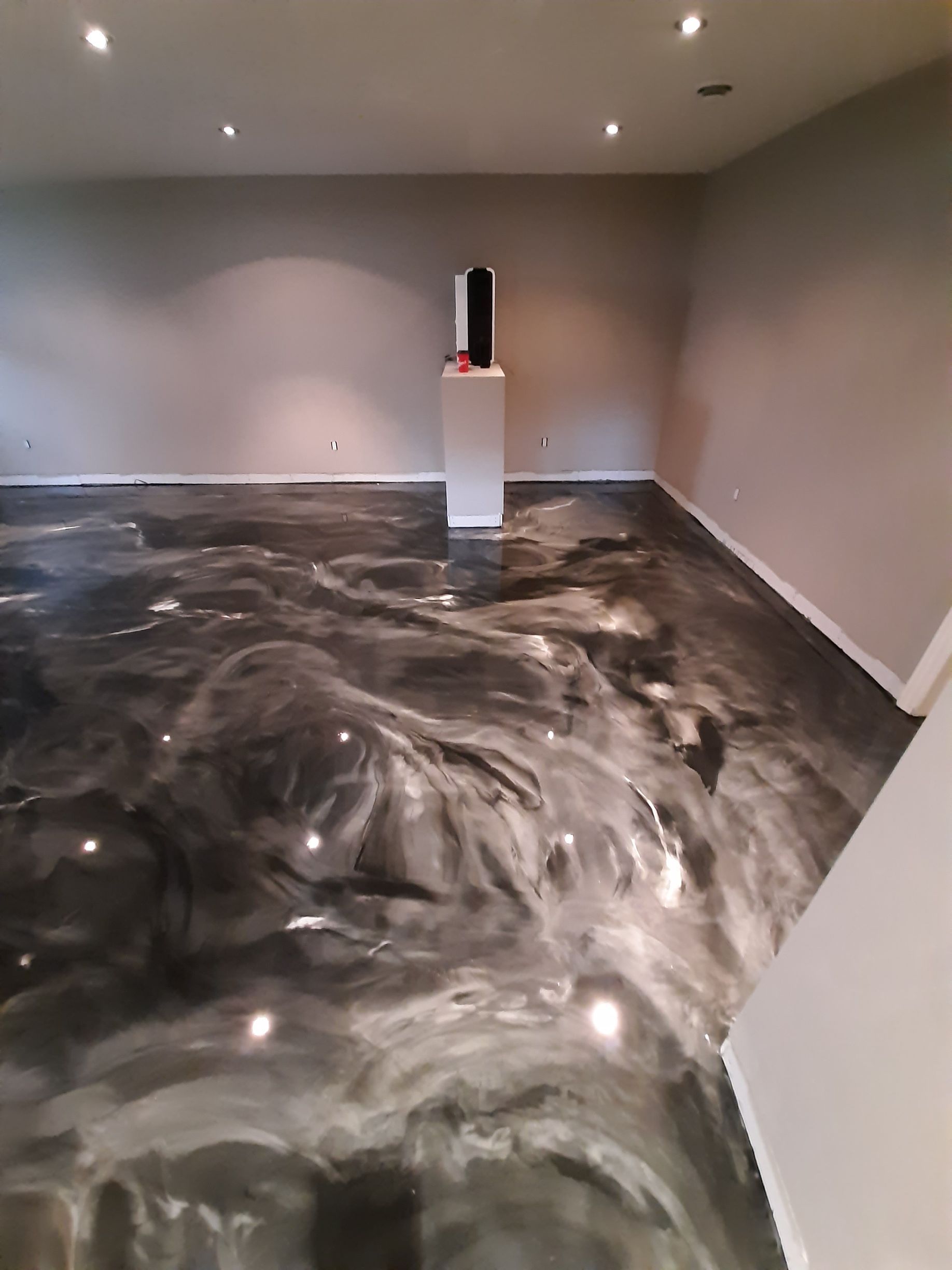 A room with a metallic floor and a statue on a pedestal.