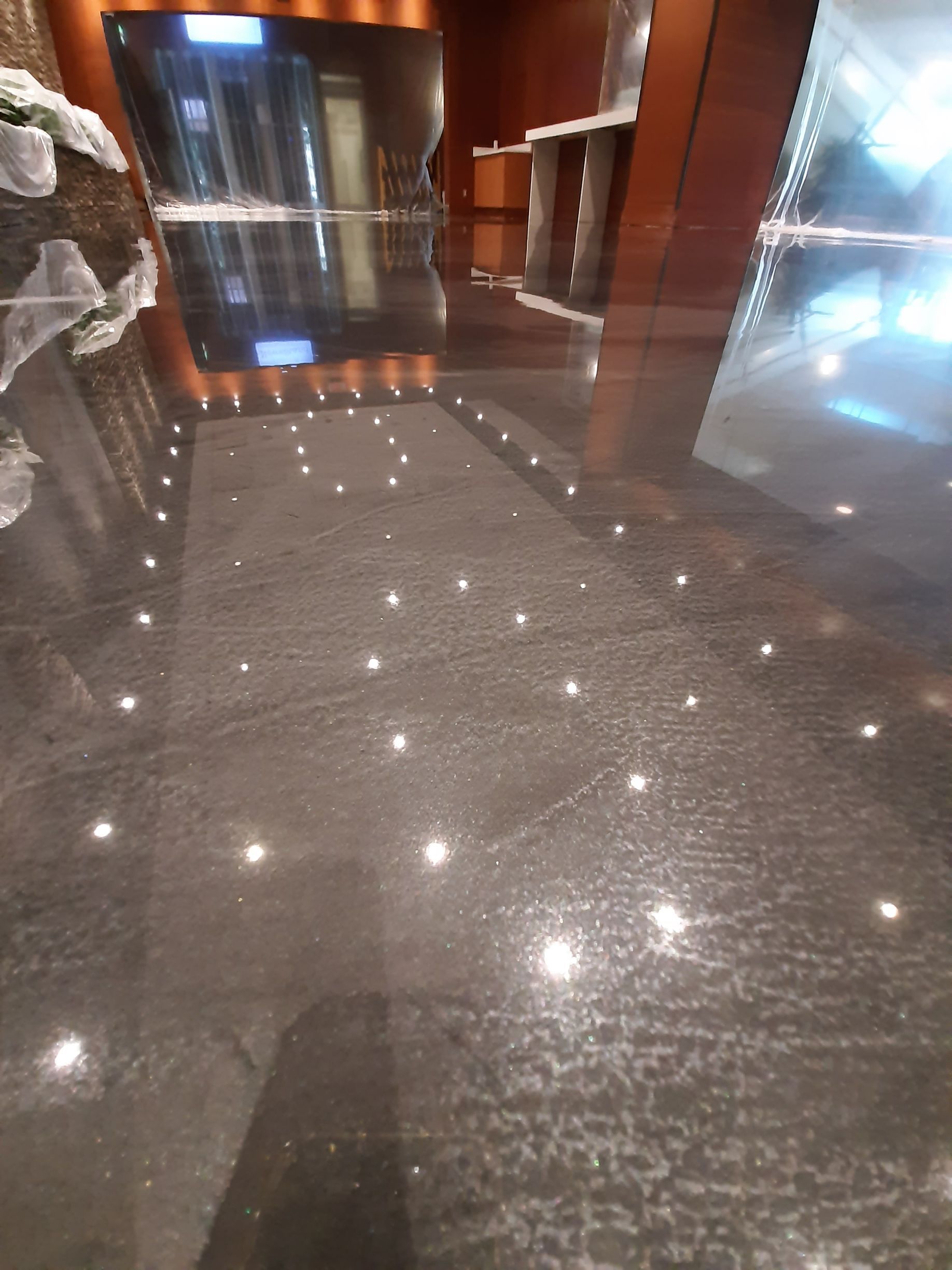 A black marble floor with a lot of lights on it