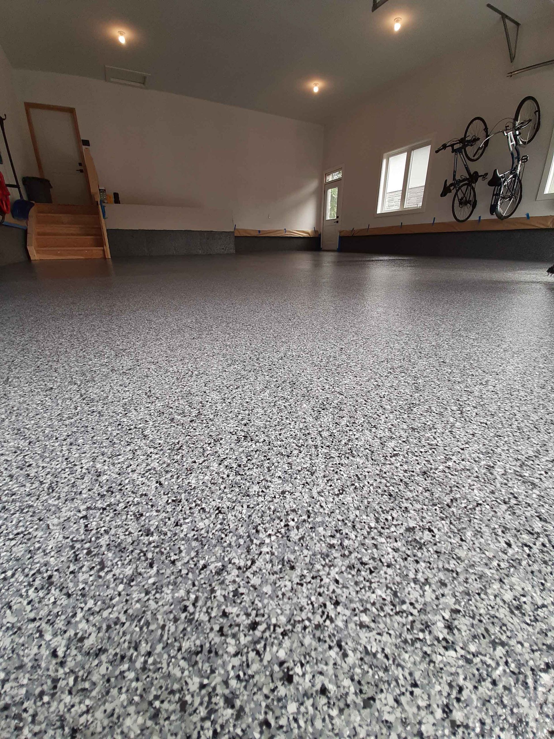 A garage with a concrete floor and bikes on the wall.