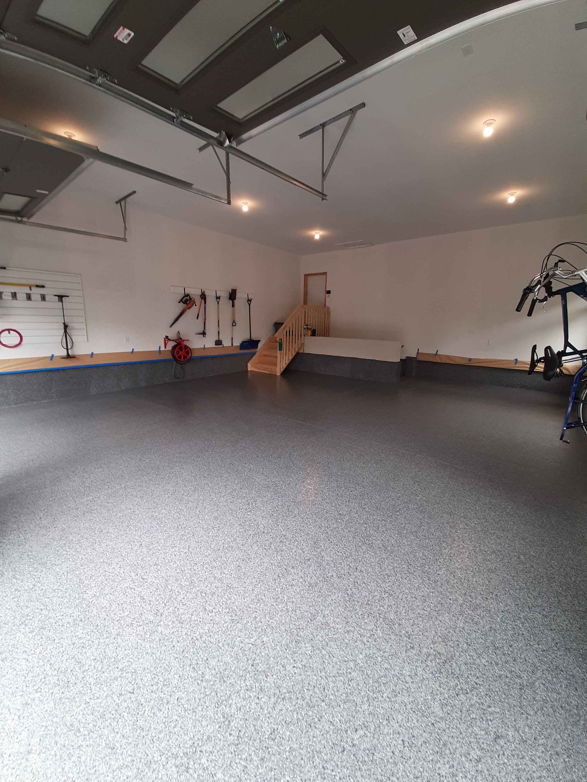 A large garage with a gray floor and white walls.
