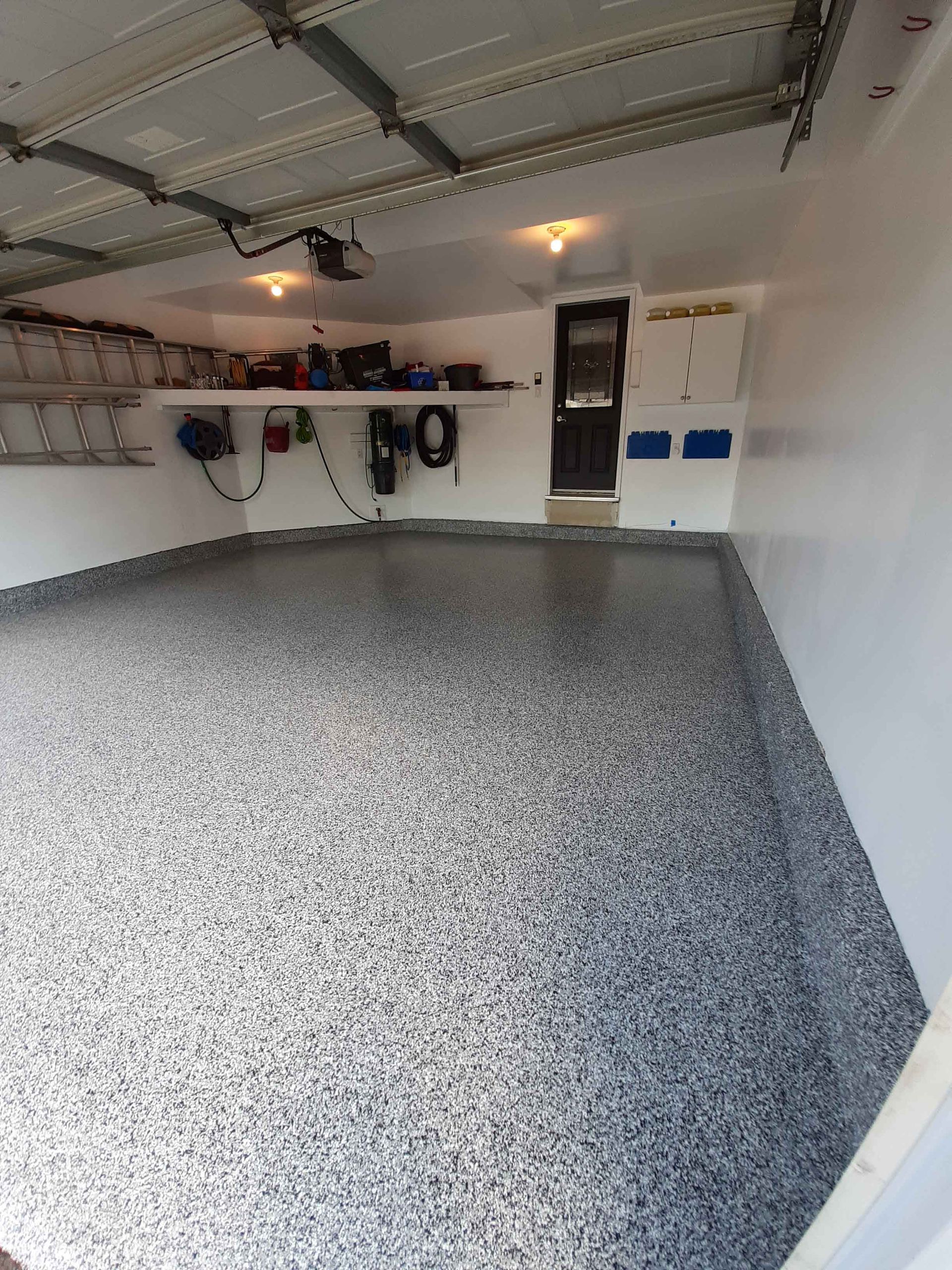 A garage with a gray floor and white walls