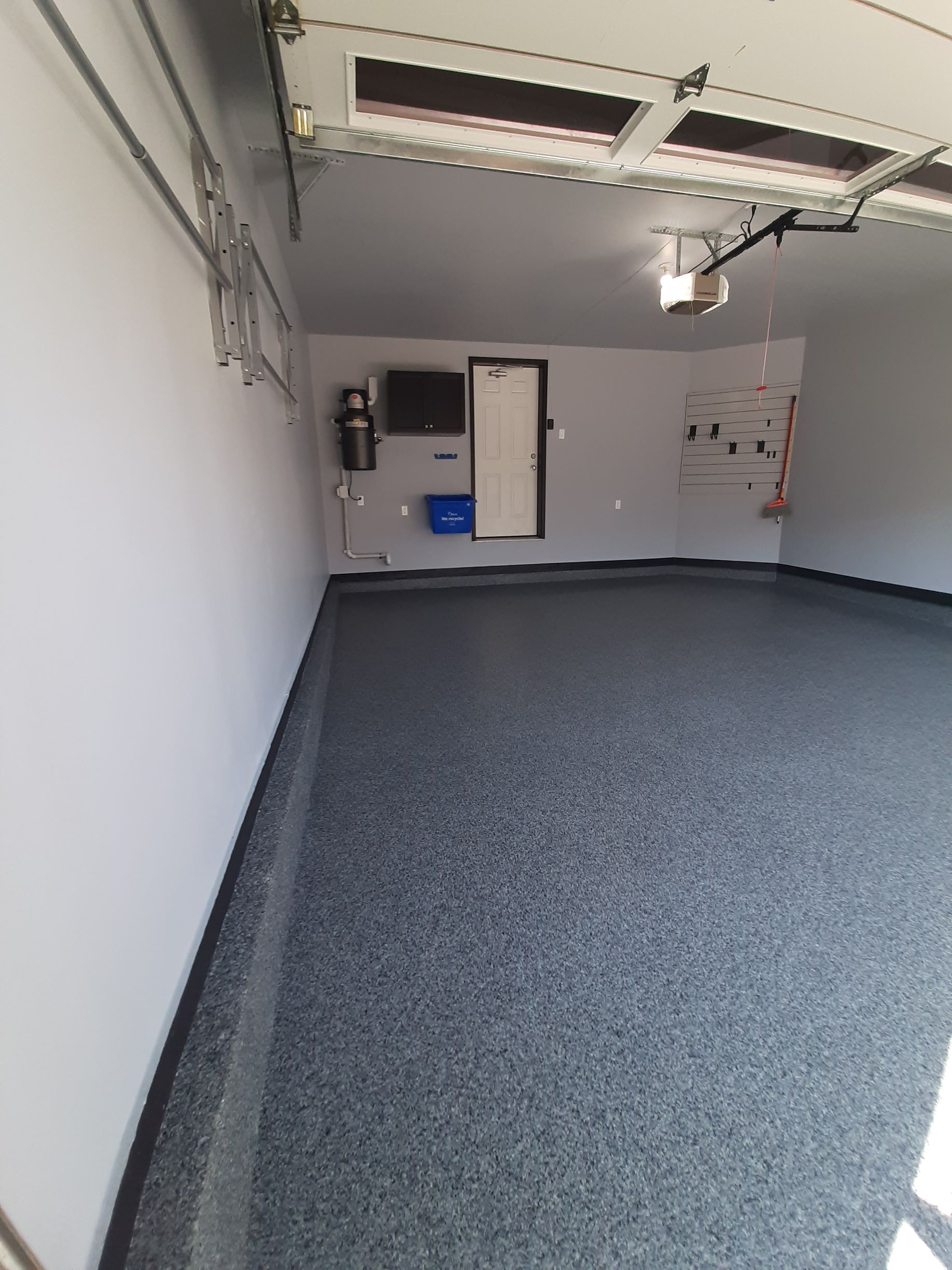 A garage with a garage door open and a gray floor.