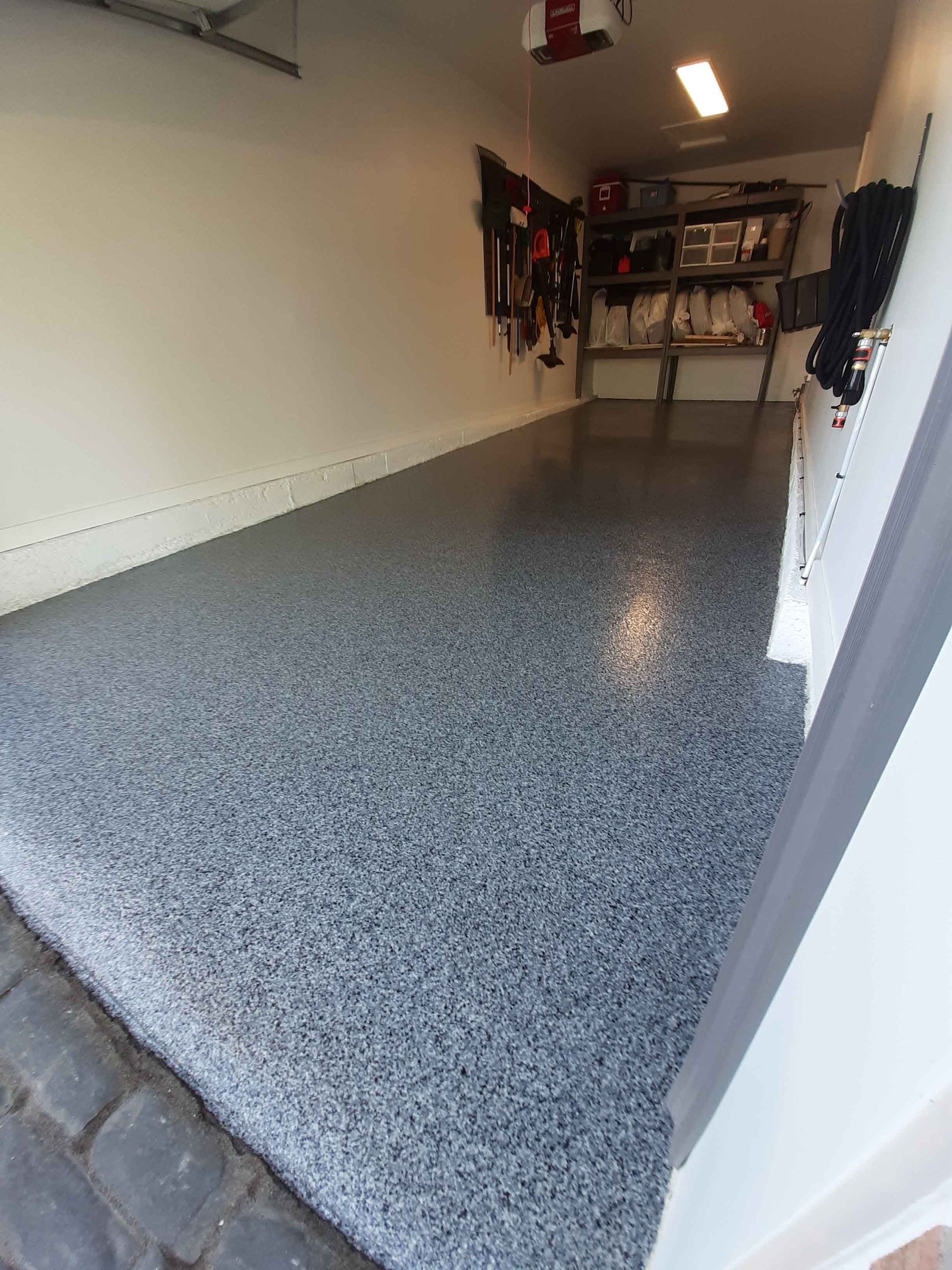 A garage with a gray floor and white walls.