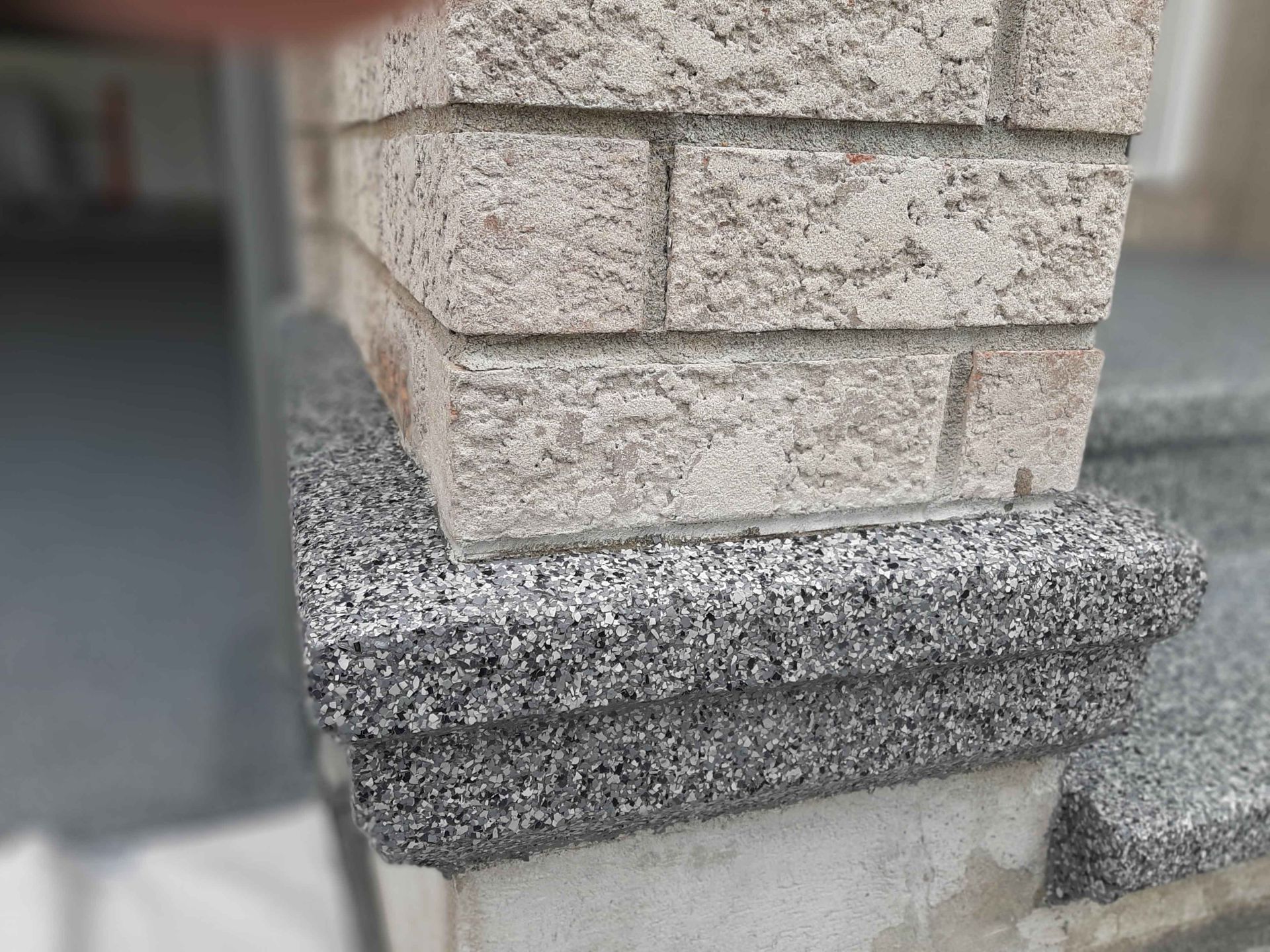 A close up of a brick wall with stairs in the background.