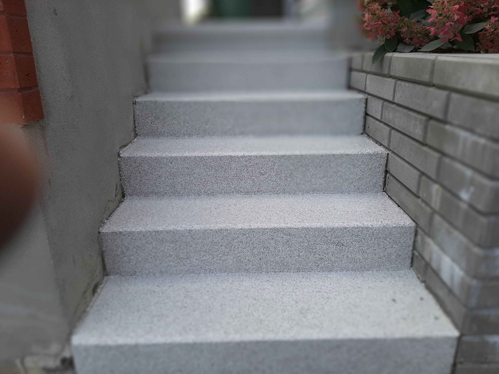 A set of stairs leading up to a brick wall.