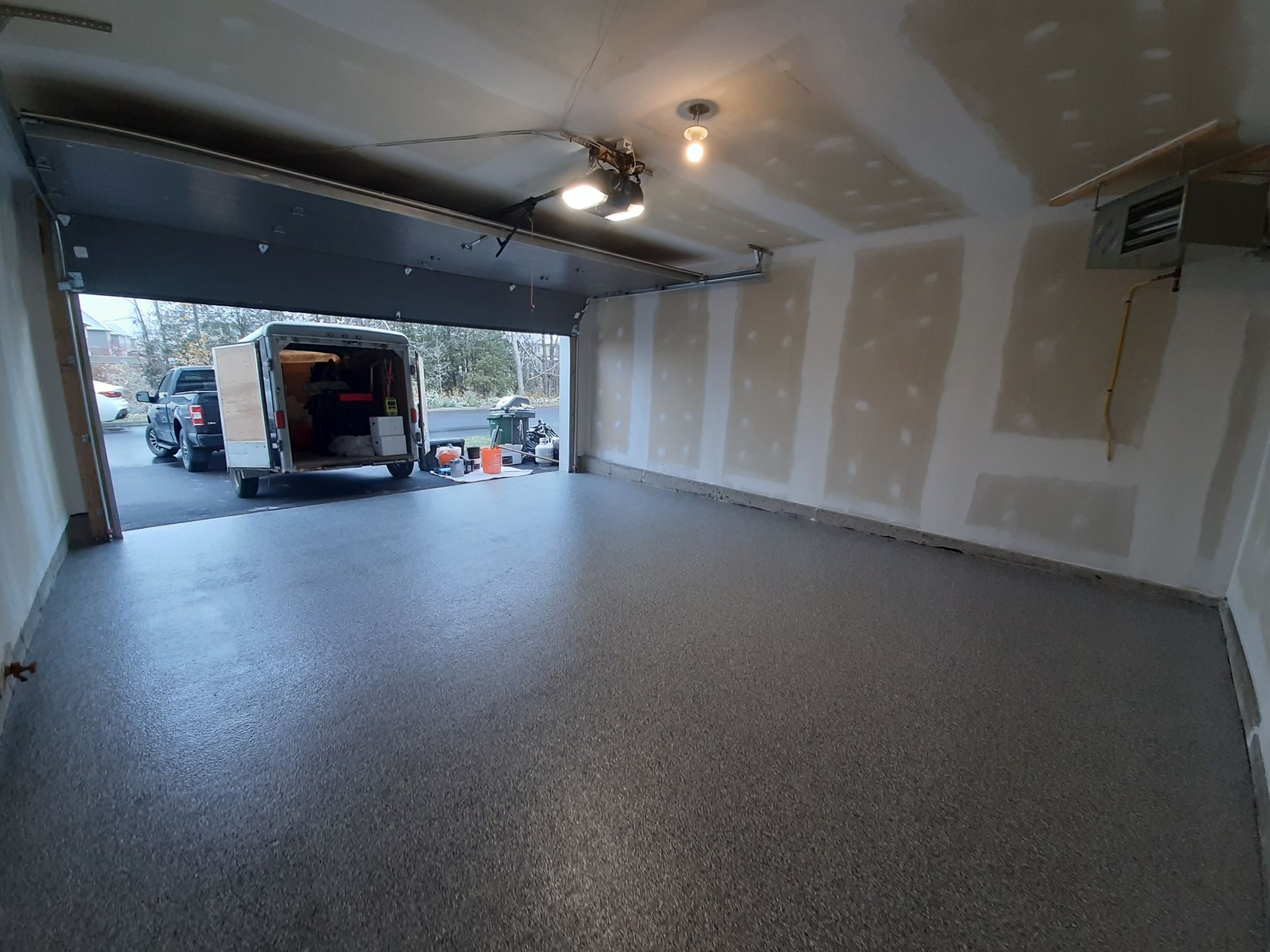 A van is parked in a garage with the door open.