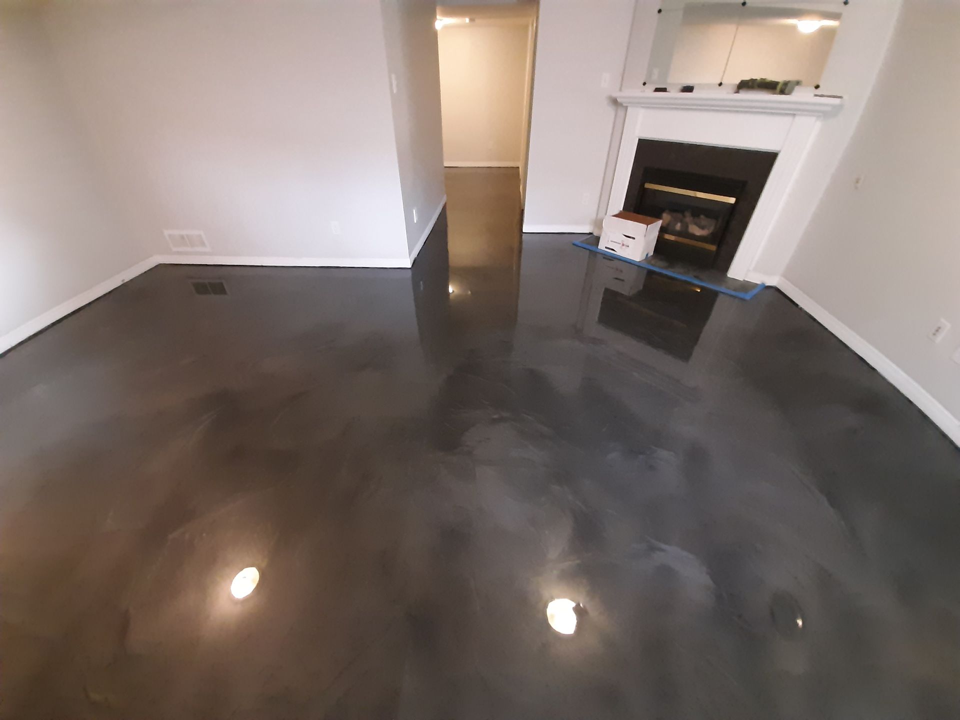 A living room with a fireplace and a black floor