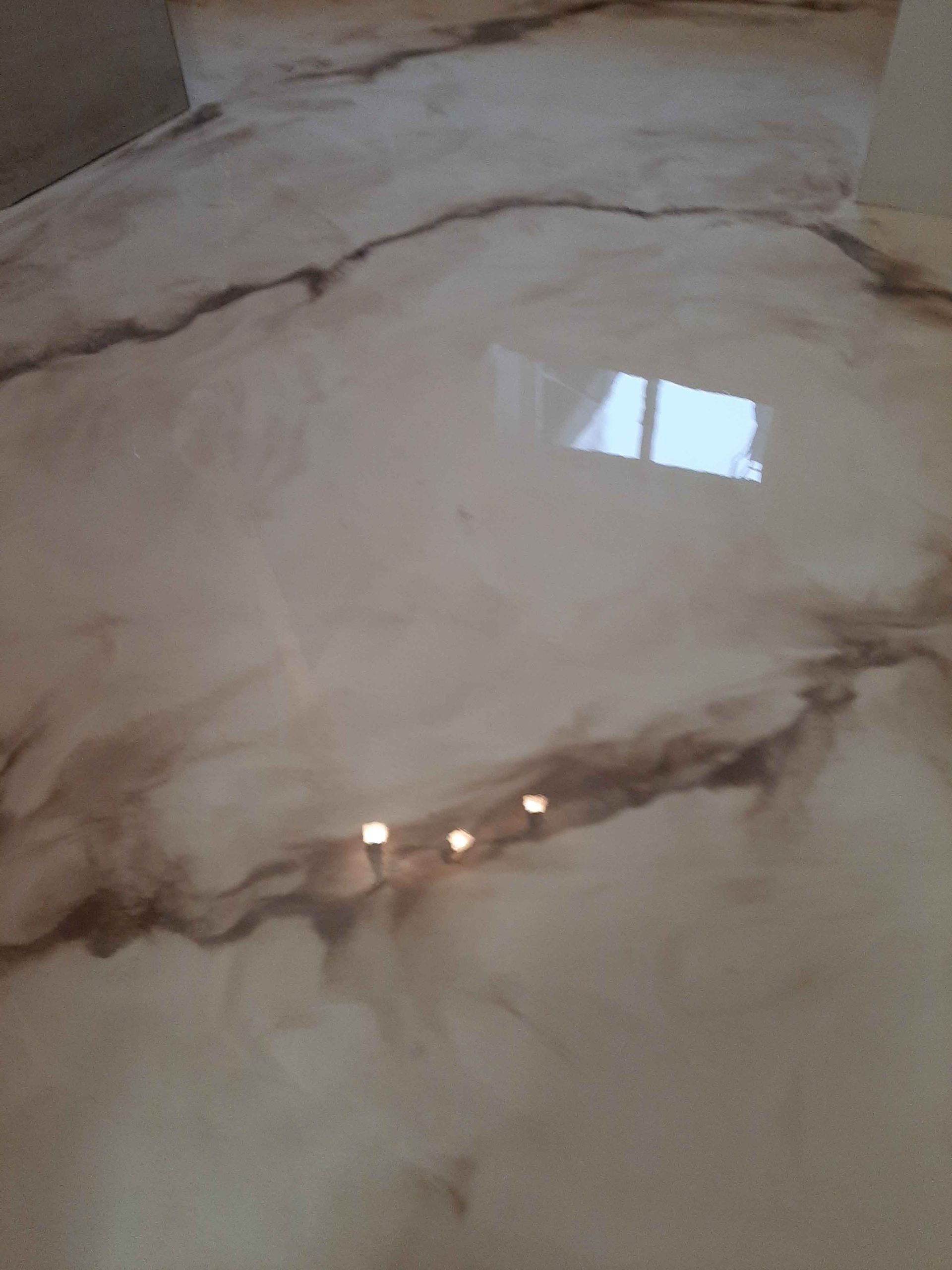 A close up of a marble floor with a window in the background.