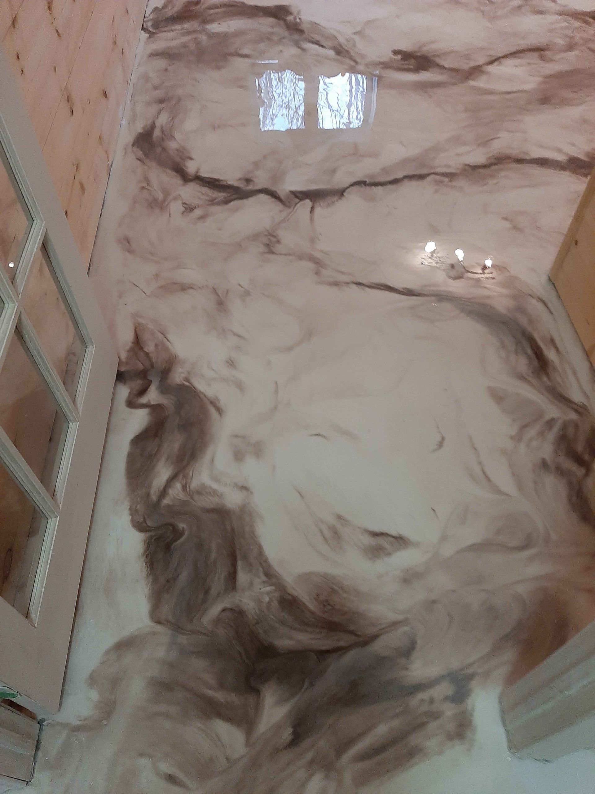 A close up of a marble floor with a staircase in the background.