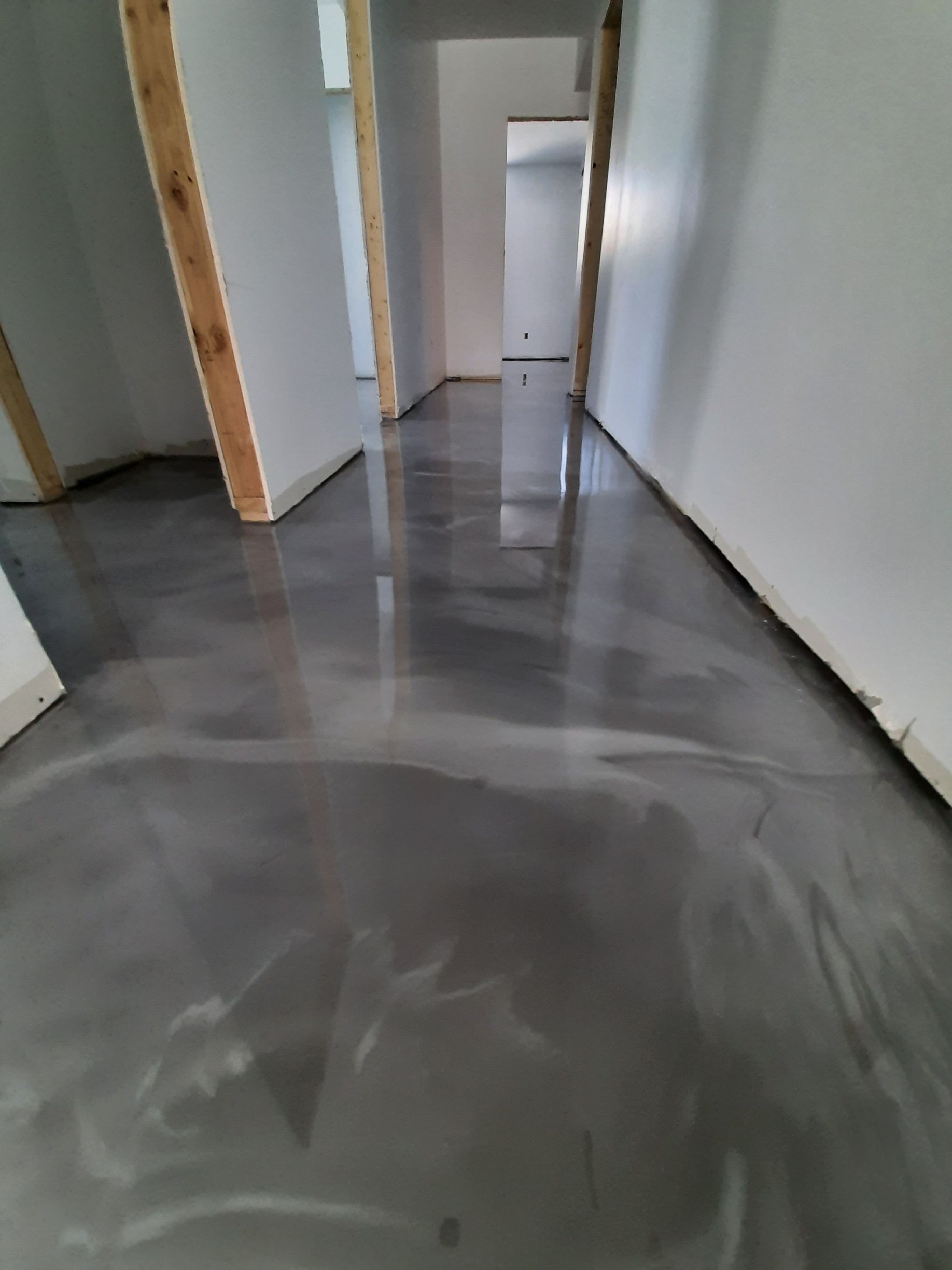 A hallway with a gray floor and white walls