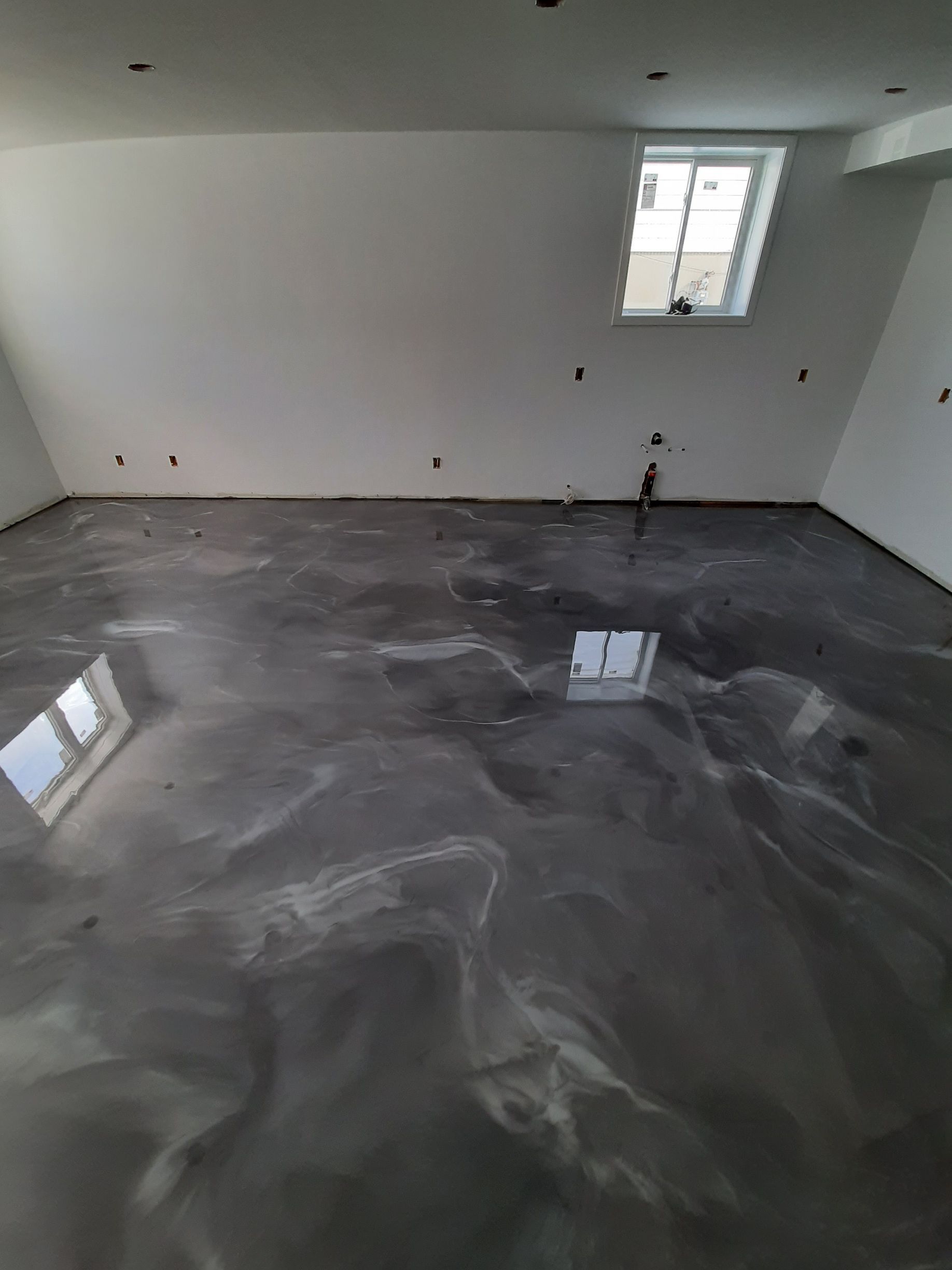 A room with a shiny metallic floor and a window.