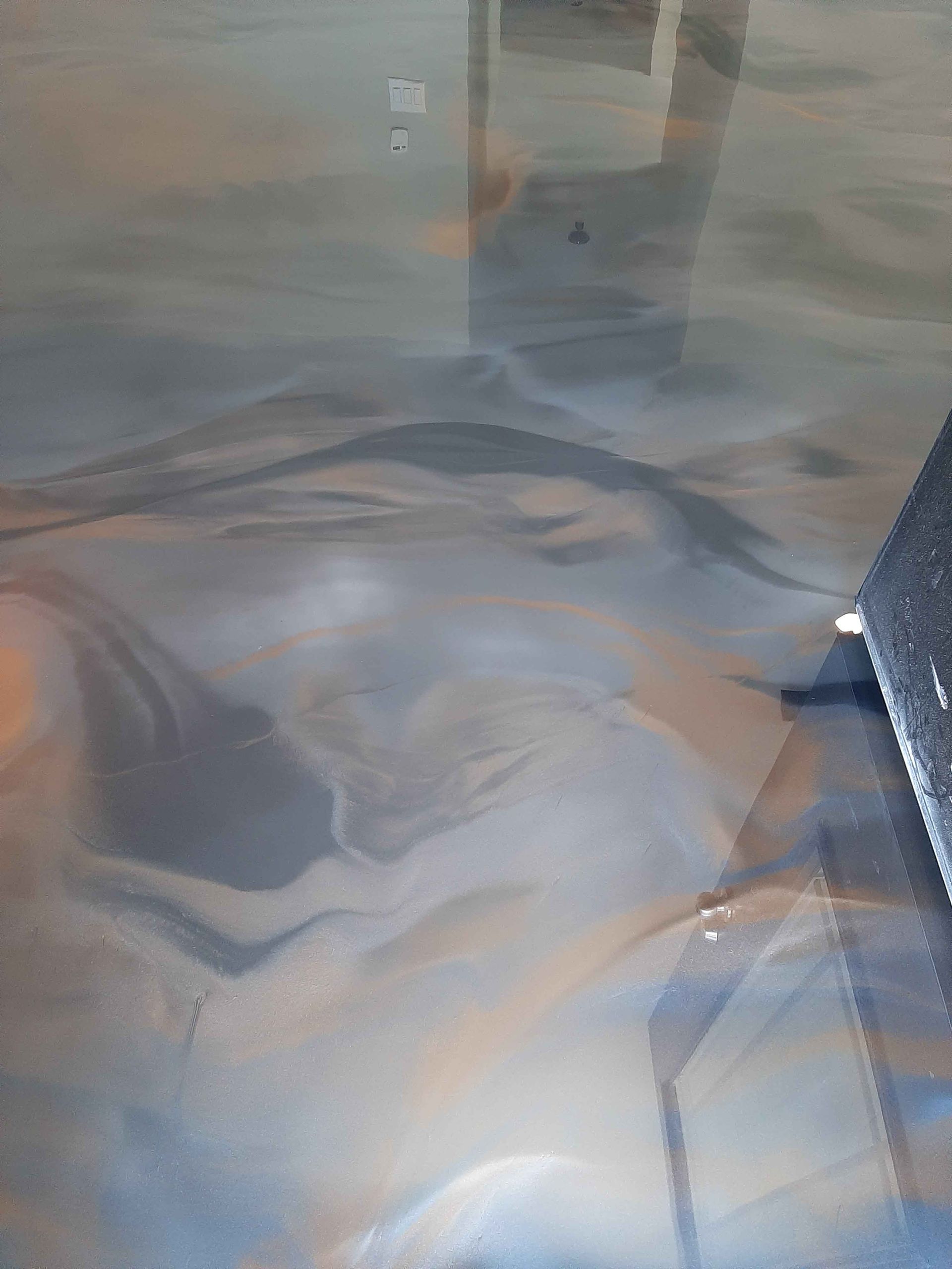 A close up of a metallic floor with a marble pattern.