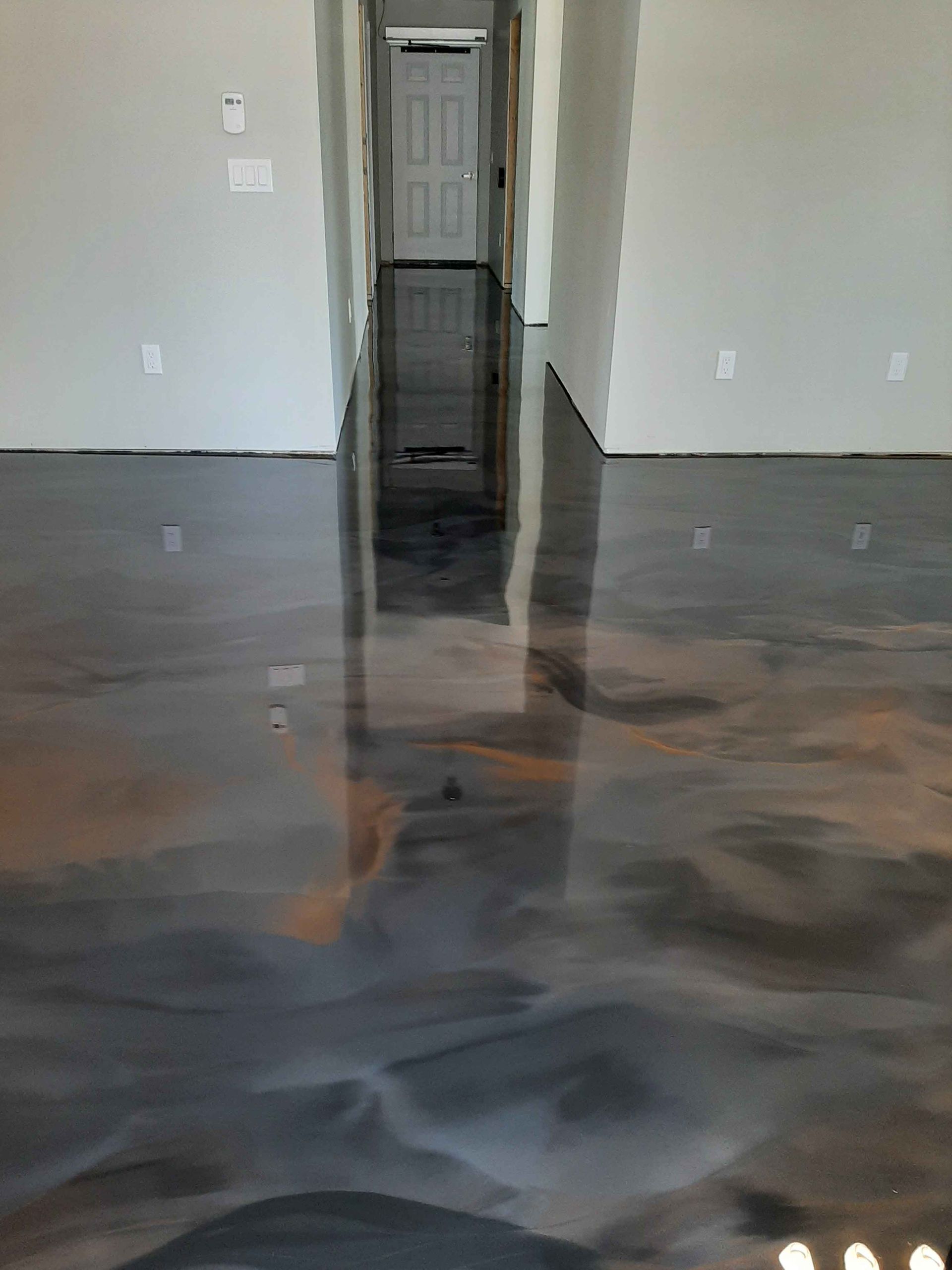 A living room with a shiny metallic floor and a hallway.