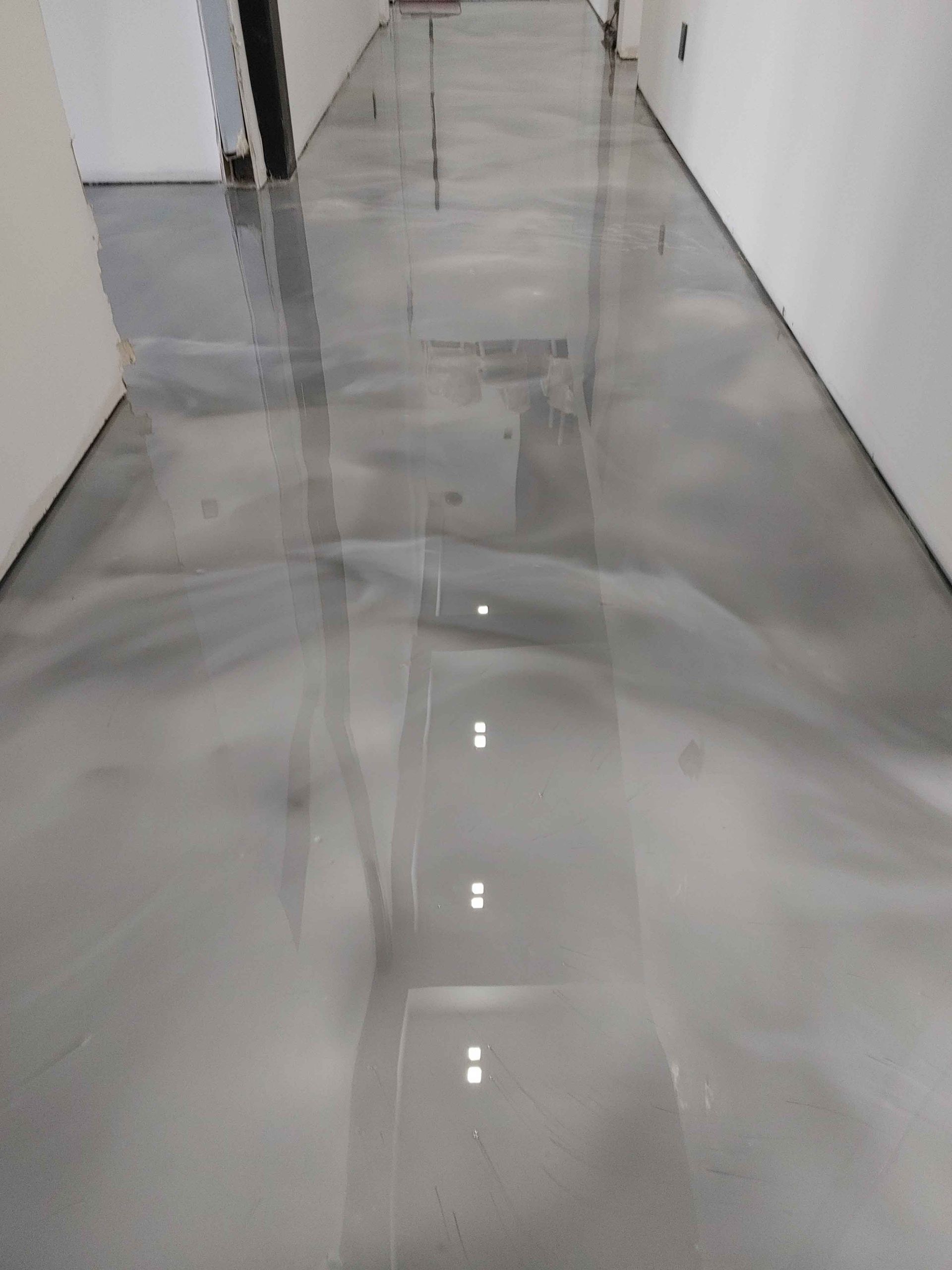 A hallway with a shiny metallic floor and white walls.