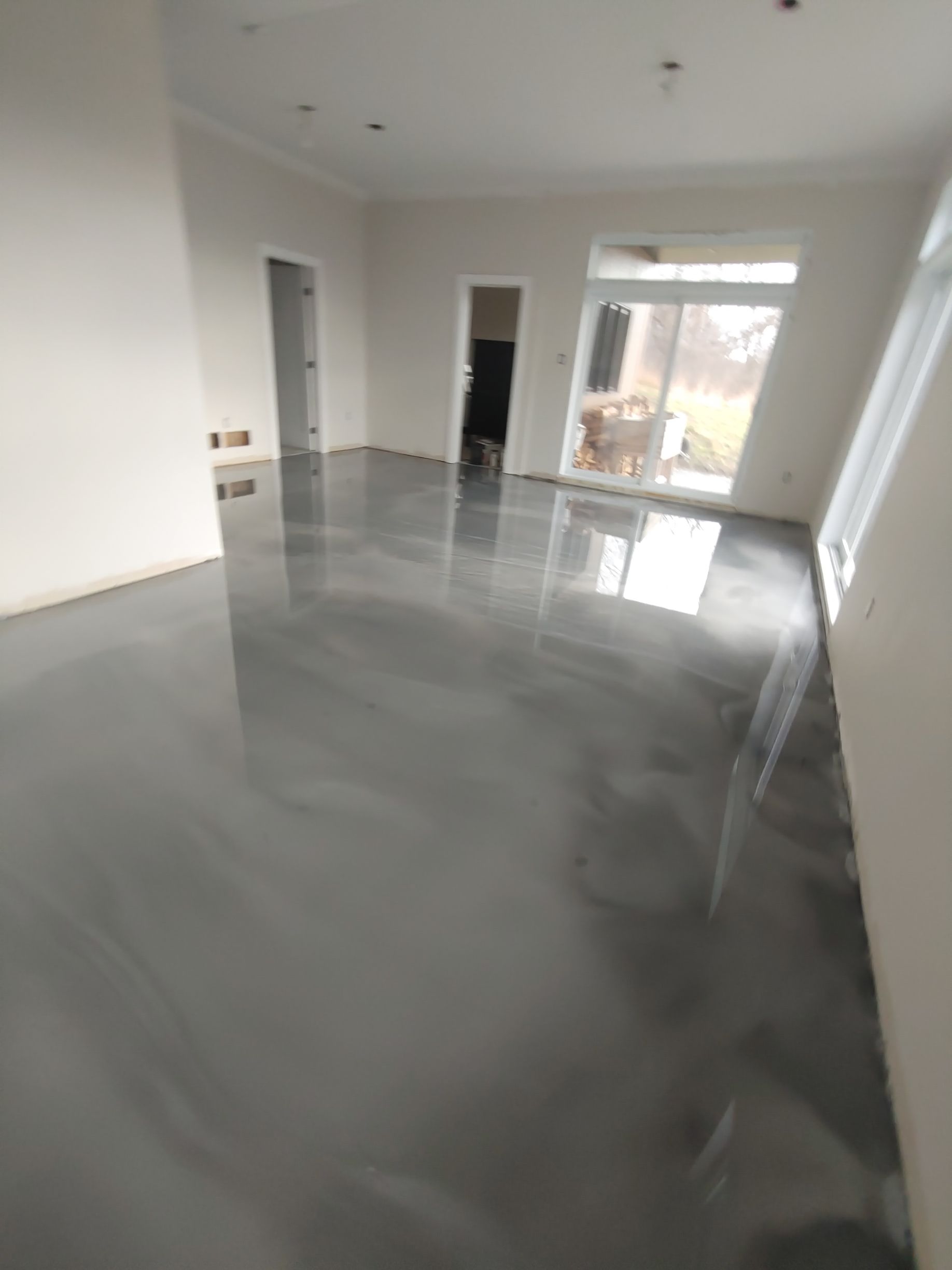 A living room with a gray metallic floor and white walls.