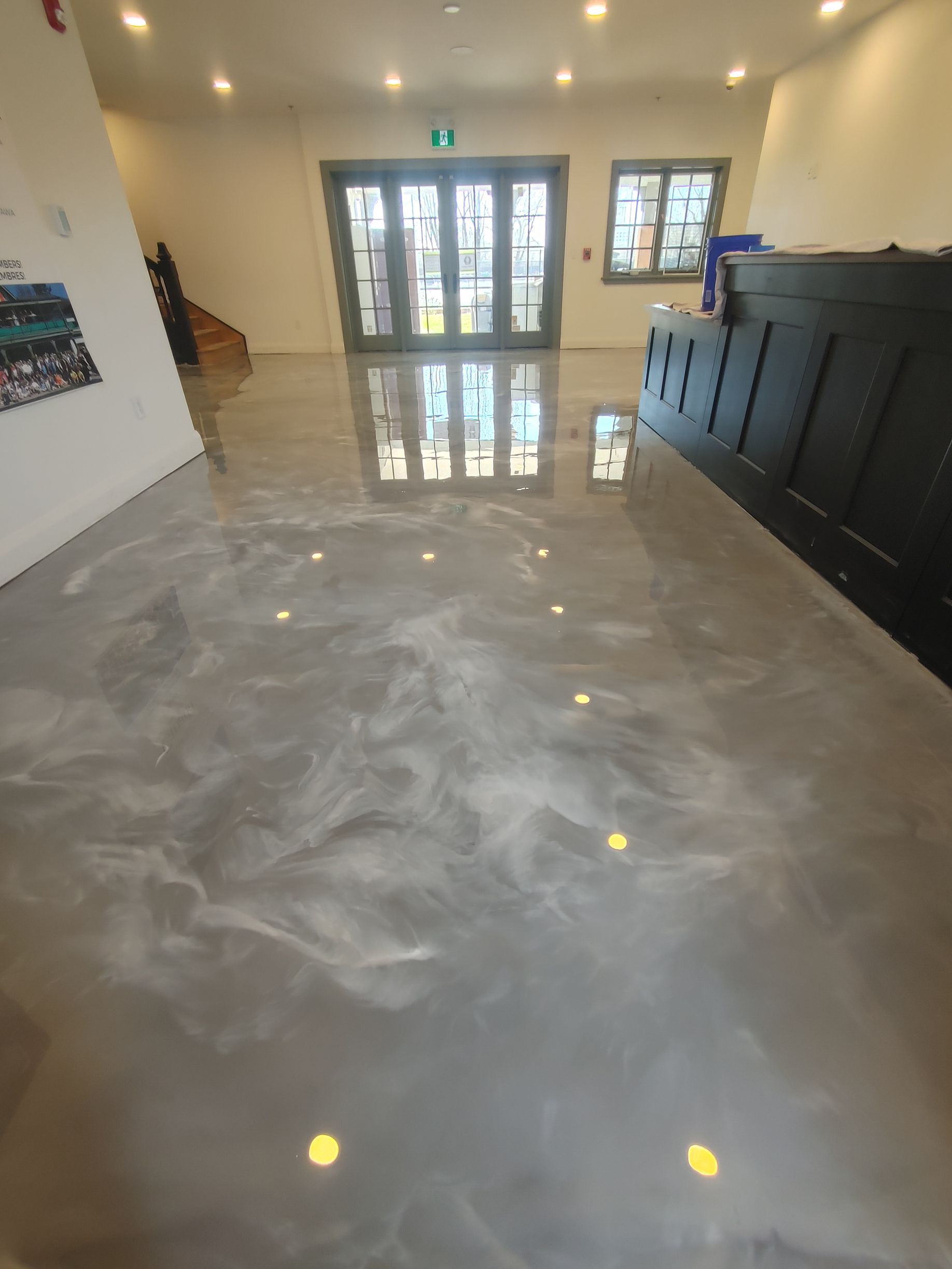 A large room with a shiny concrete floor and a large window.