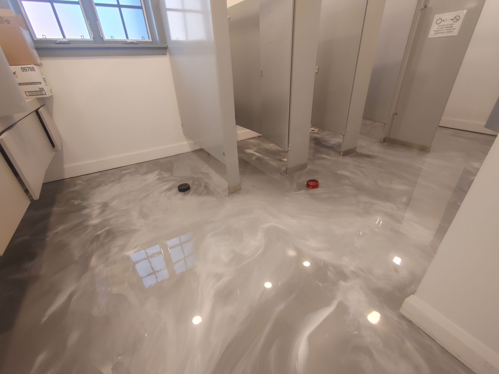 A bathroom with a shiny floor and a window.